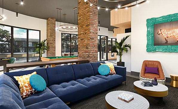 Chic lounge area with modern decor featuring a plush blue sectional, vibrant accent pillows, and stylish art under elegant lighting.