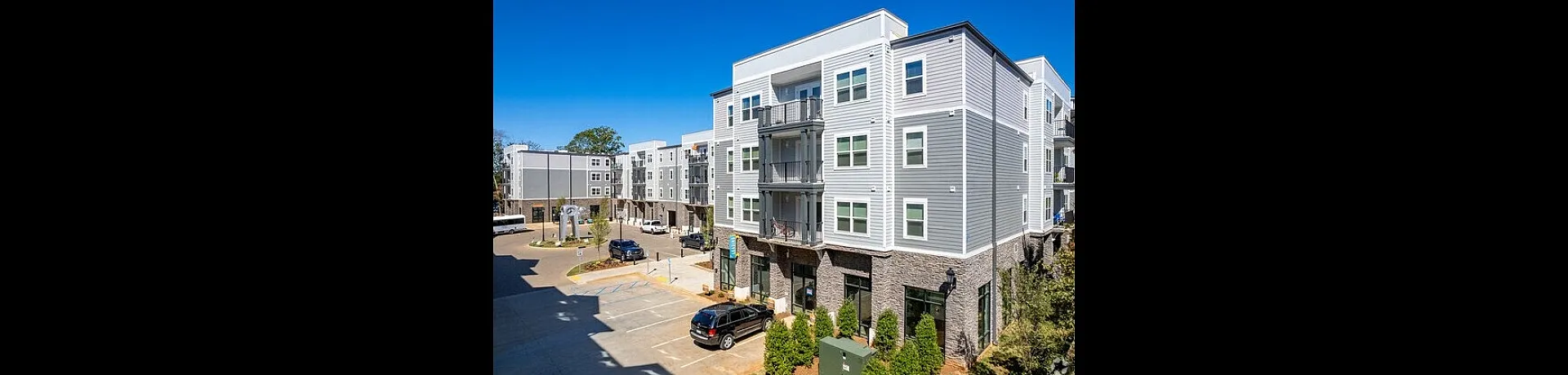 Modern apartment complex with sleek architecture, spacious balconies, and lush landscaping in a vibrant urban setting.