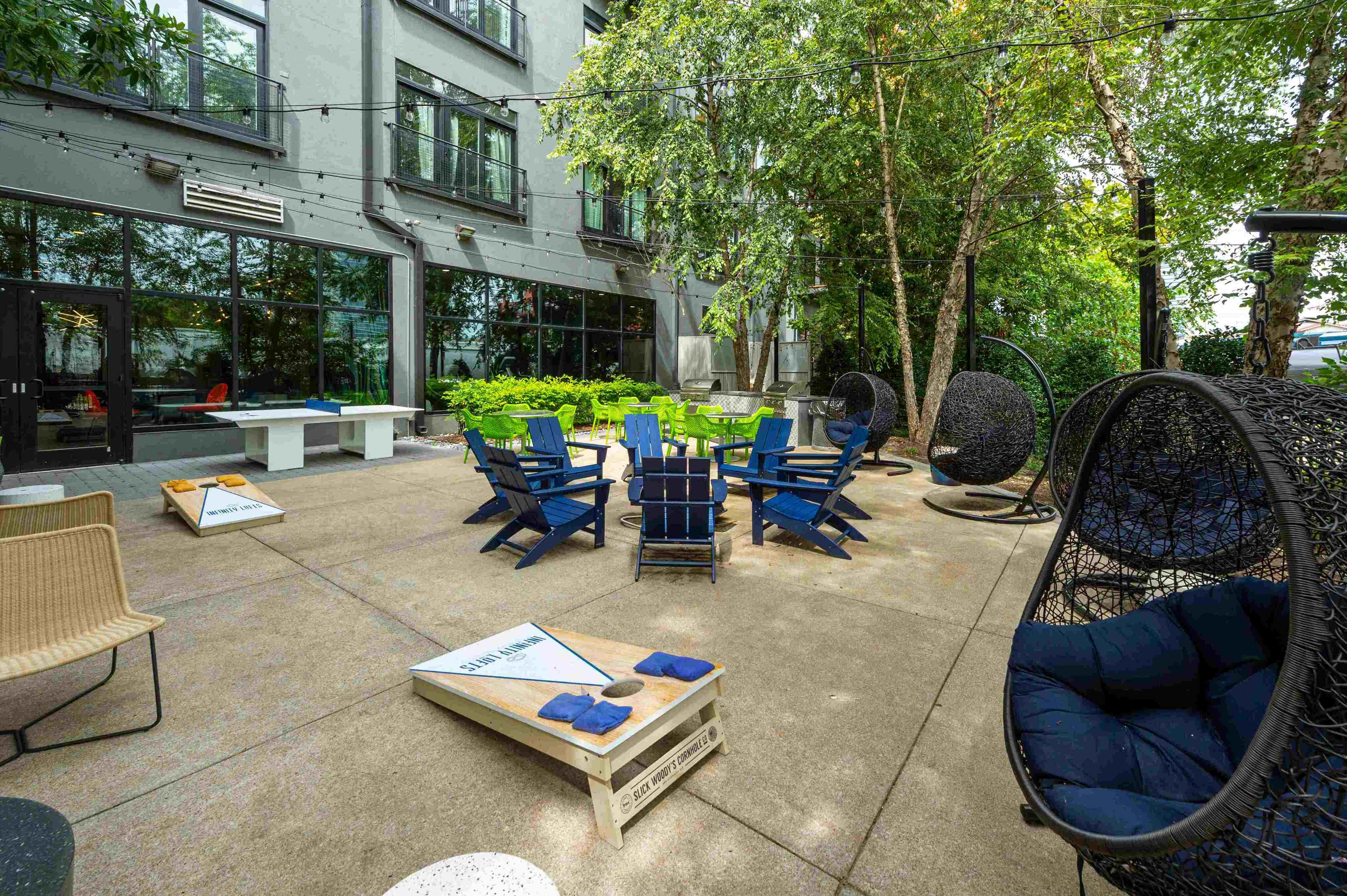 Outdoor courtyard with BBQ grills, fire pit, and games