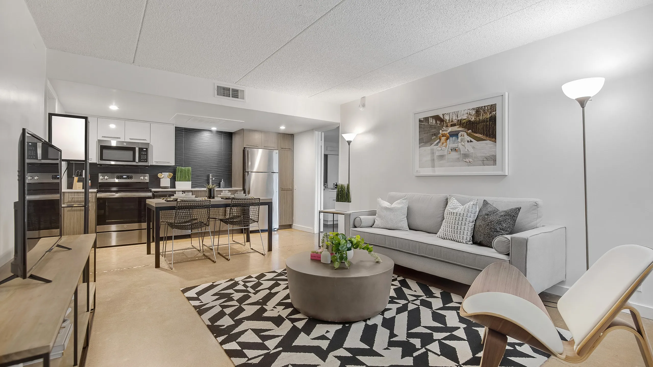 Contemporary open-concept living area featuring a stylish kitchen, elegant dining space, and cozy seating arrangement.