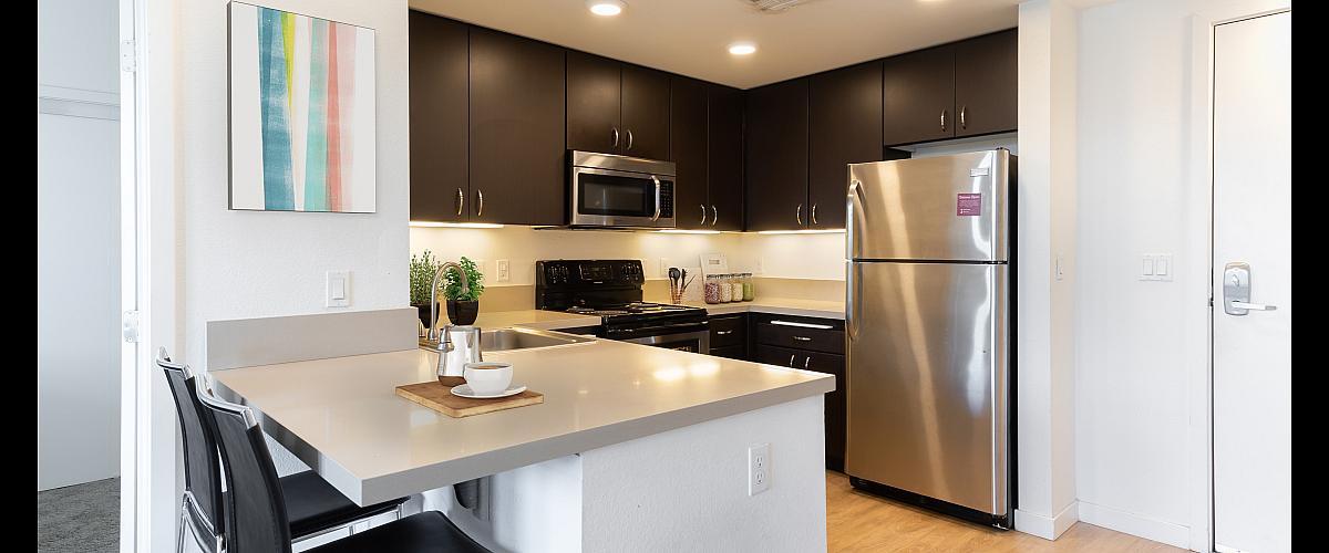 Modern kitchen with sleek countertops, stainless steel appliances, and chic bar seating offering a stylish, contemporary feel.