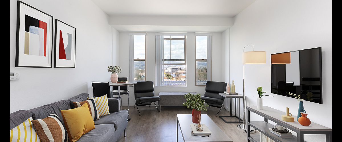 Bright and inviting living room featuring modern decor, large windows with a scenic view, and comfortable seating.