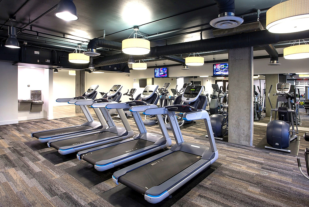 Modern apartment gym featuring state-of-the-art treadmills and cardio equipment in a sleek, well-lit space.