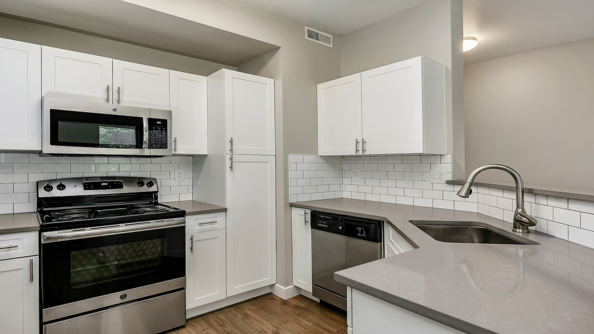 Modern kitchen with sleek stainless steel appliances, elegant white cabinetry, and a stylish subway tile backsplash.