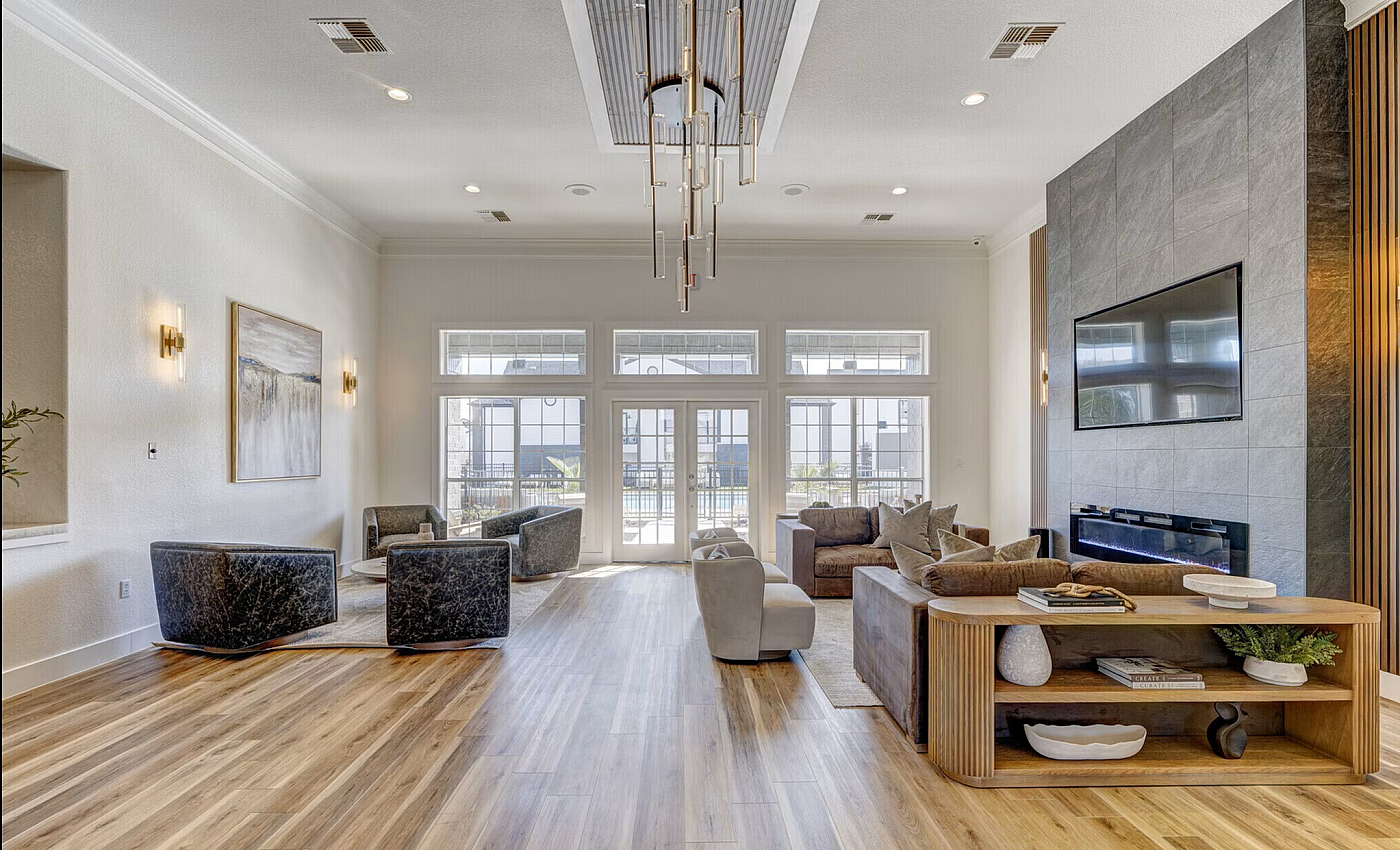Elegant and modern living room with sleek flooring, stylish seating, large windows, and a chic fireplace.