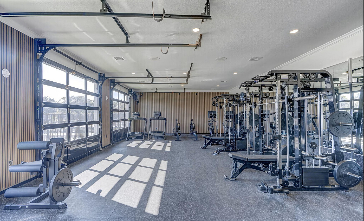Bright and spacious fitness gym with state-of-the-art equipment, large windows, and modern design.