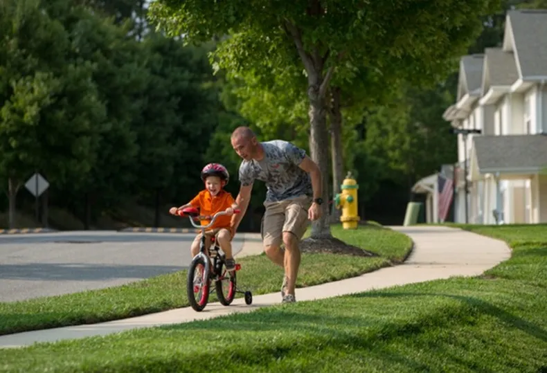 Child riding bike down sidewalk at Fort Bragg