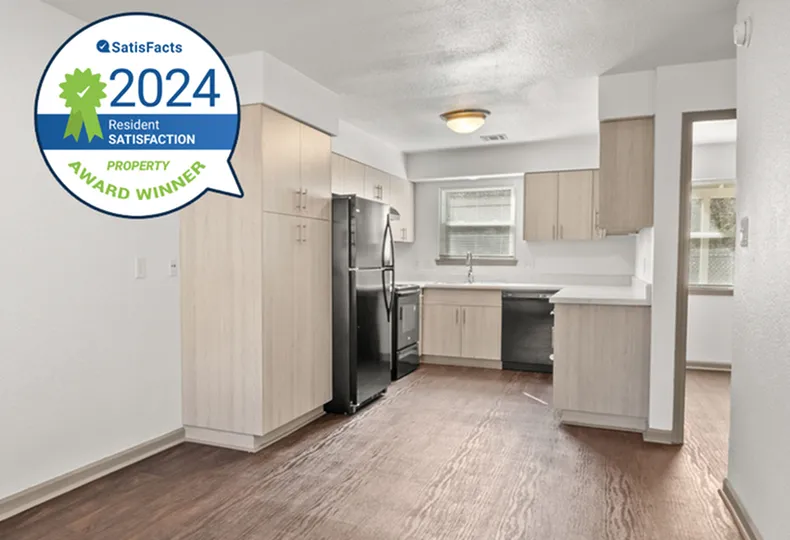 Contemporary kitchen with light wood cabinets, stainless steel appliances, and stylish design, 2024 resident satisfaction award winner.