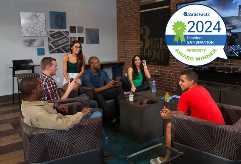 Vibrant lounge area with residents enjoying a cozy gathering space, featuring modern decor and award-winning satisfaction notice.