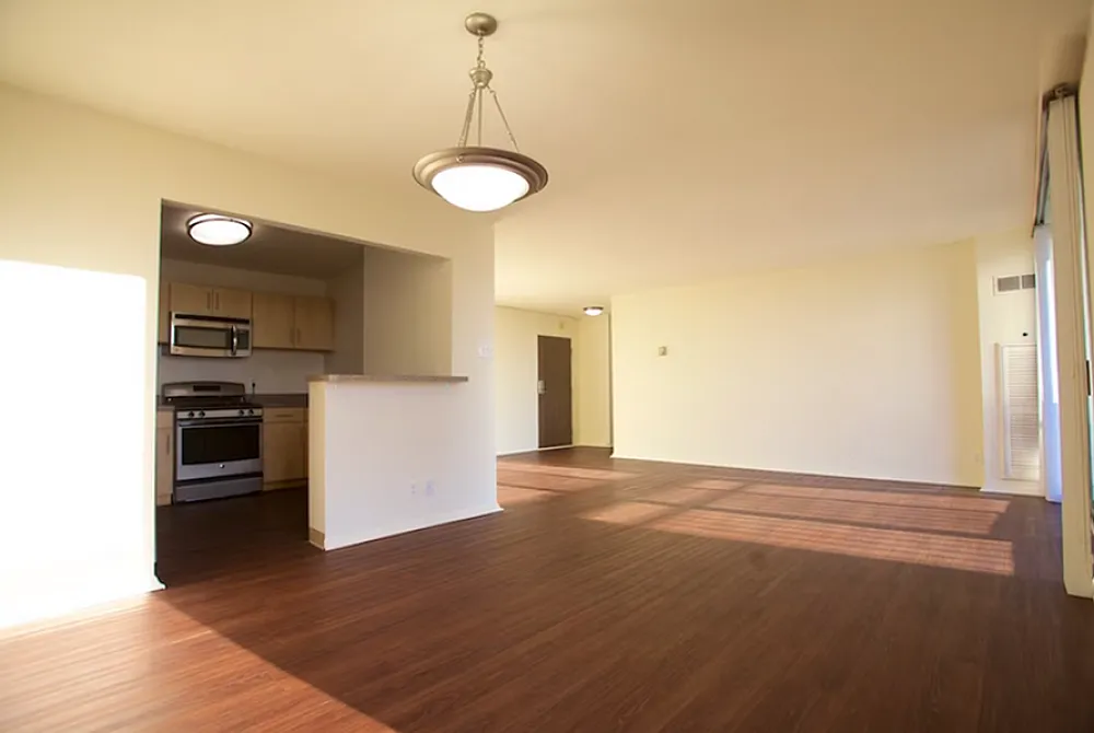 Spacious apartment featuring an open-concept living area with gleaming hardwood floors and a modern kitchen.