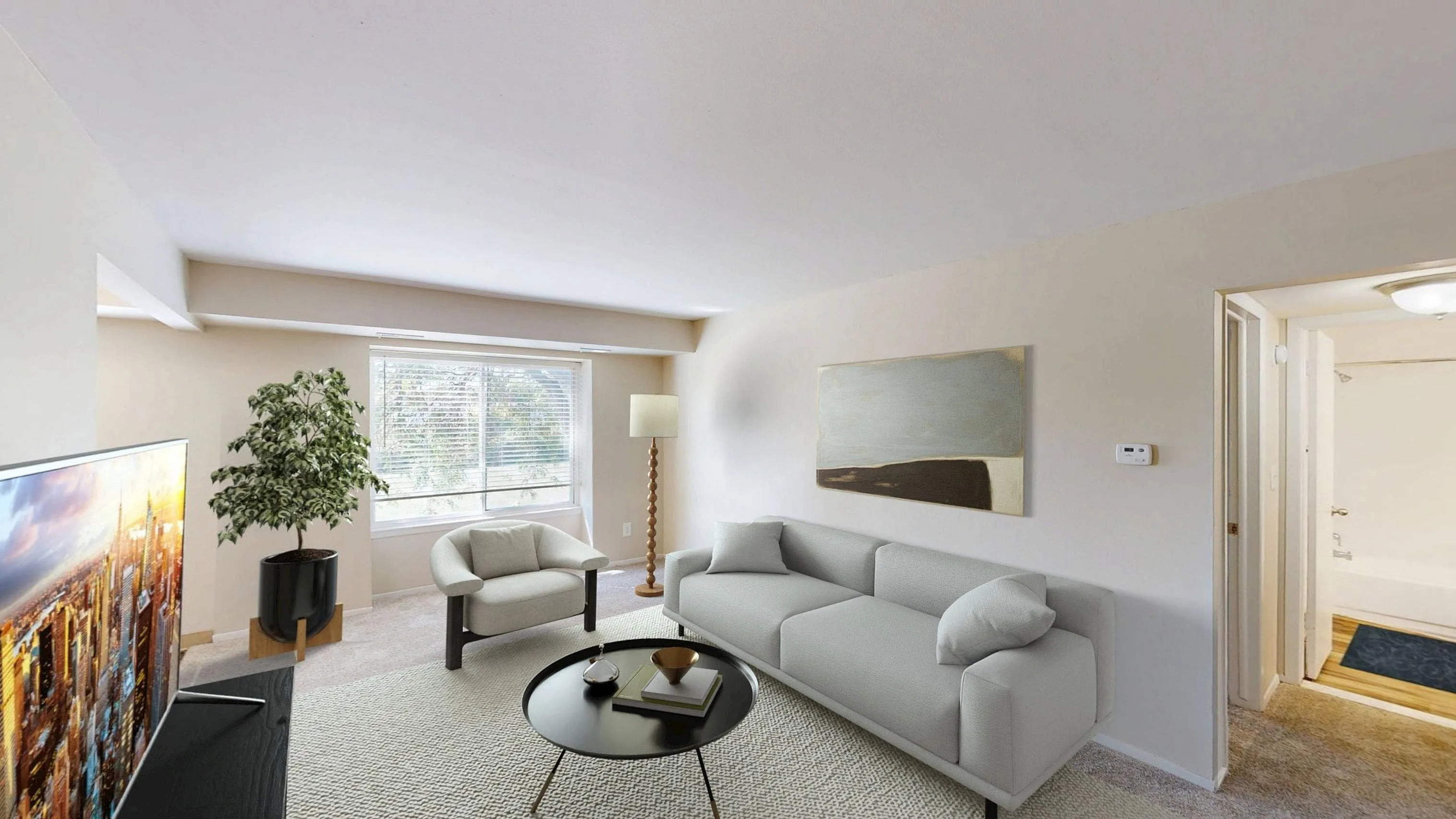Bright and modern living room with a sleek sofa, stylish armchair, and a vibrant wall painting. Features a large window offering ample natural light and views of the greenery outside, complemented by a potted plant and a contemporary floor lamp.