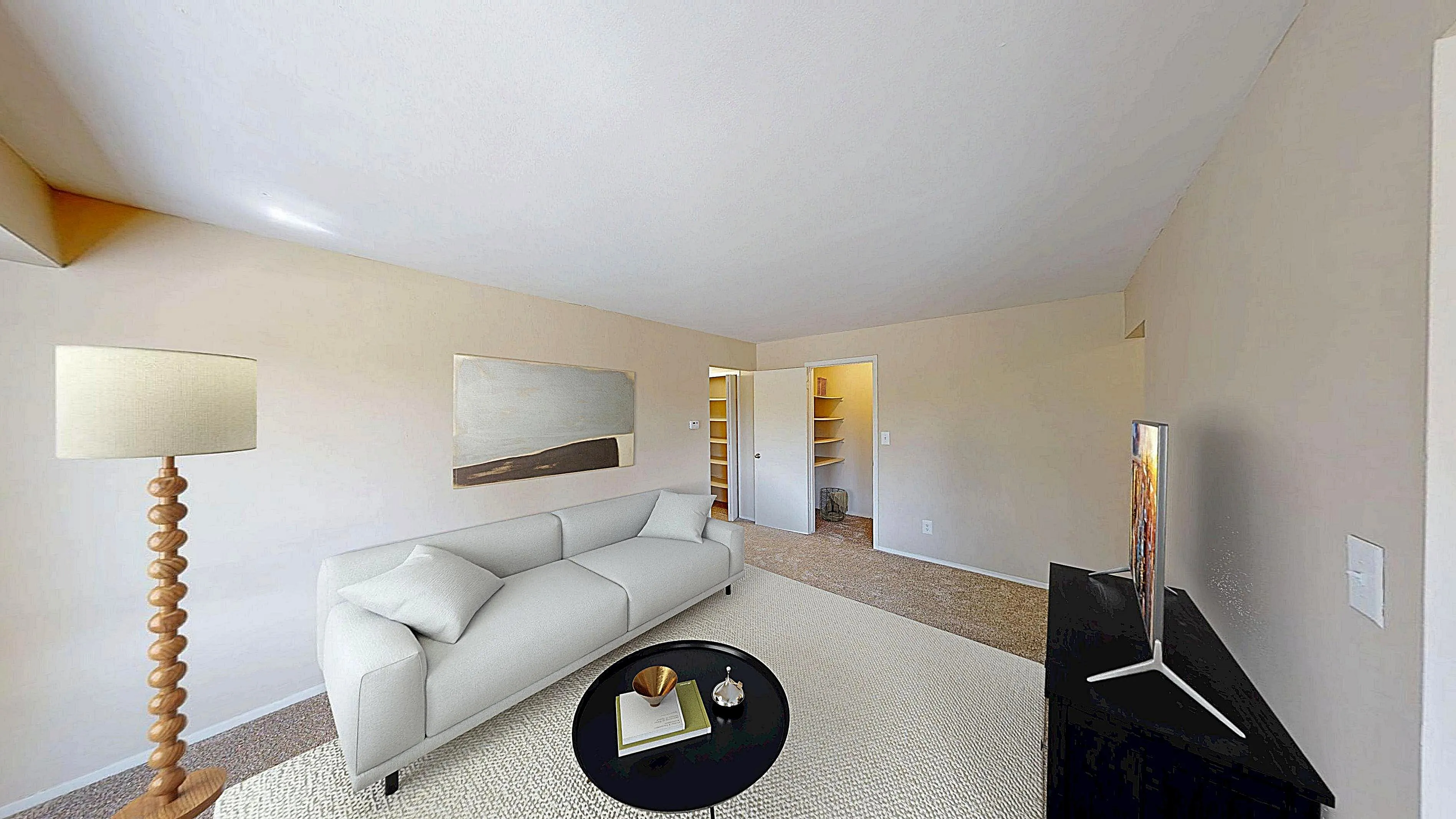 Bright and modern living room with elegant beige walls, stylish white sofa, and sleek black table, perfect for relaxation and entertainment.