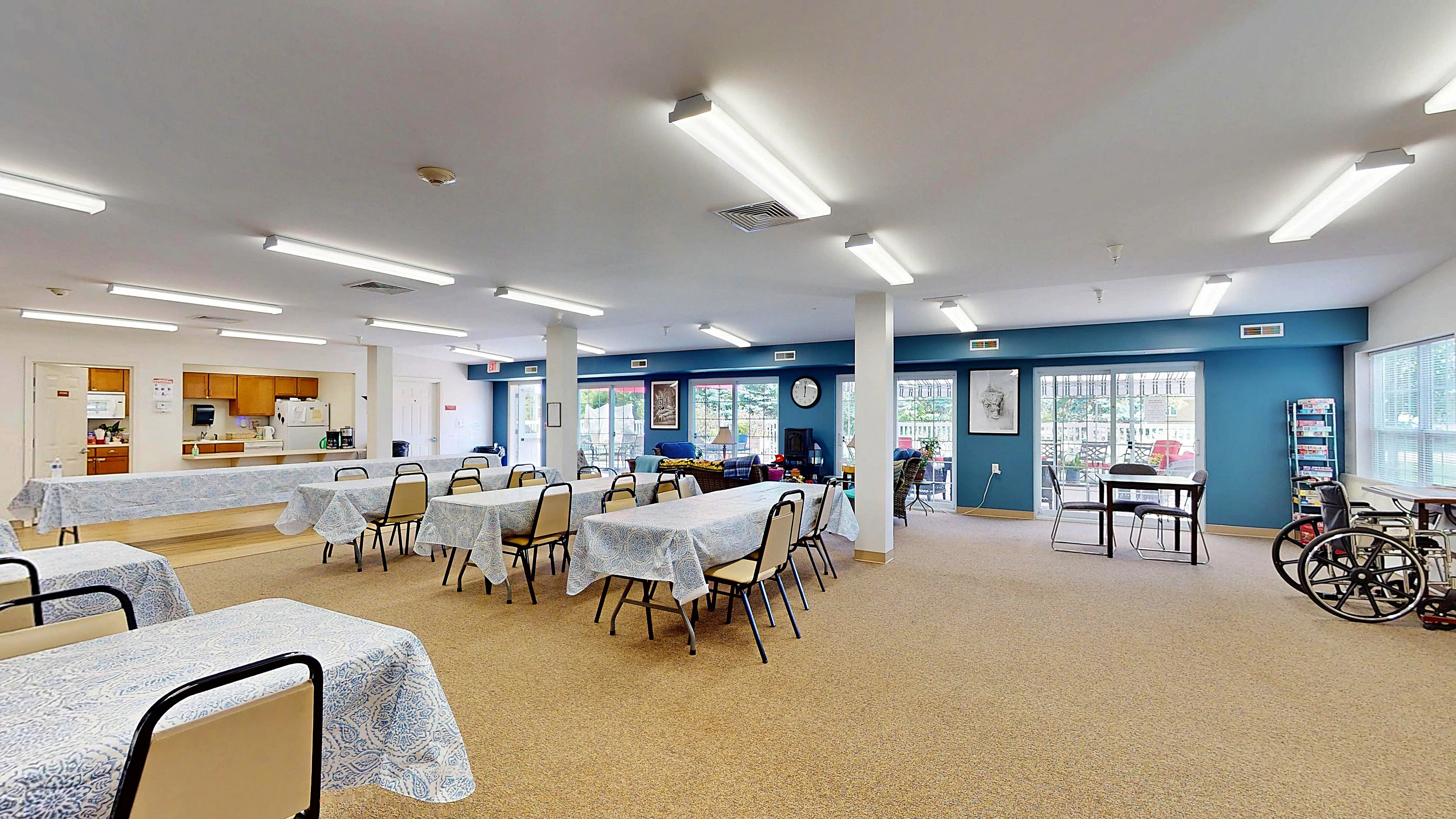 Bright and spacious communal area with dining tables, modern kitchen, and large windows for ample natural light.
