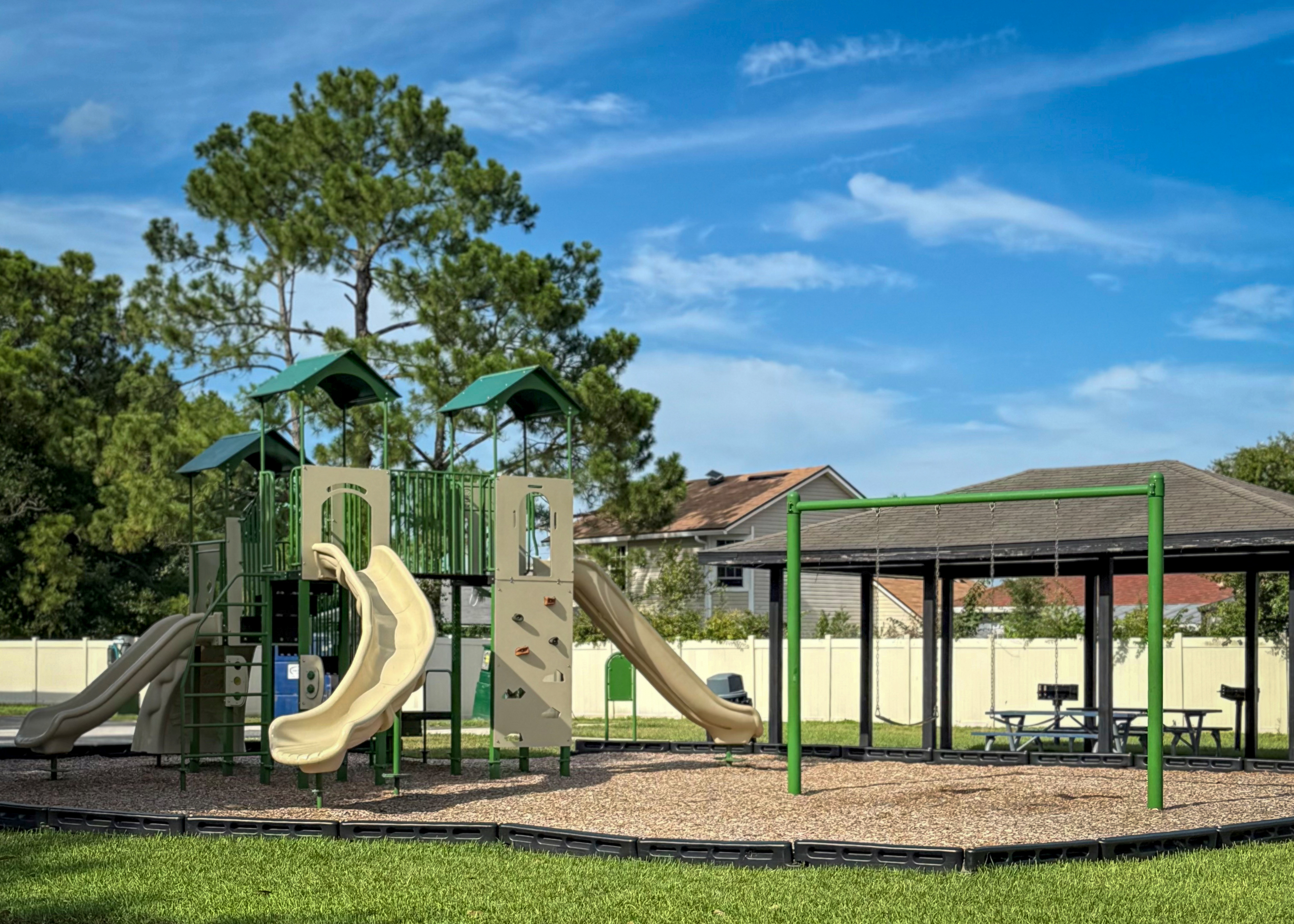 Charming outdoor playground with slides and swings surrounded by lush greenery, perfect for family enjoyment.
