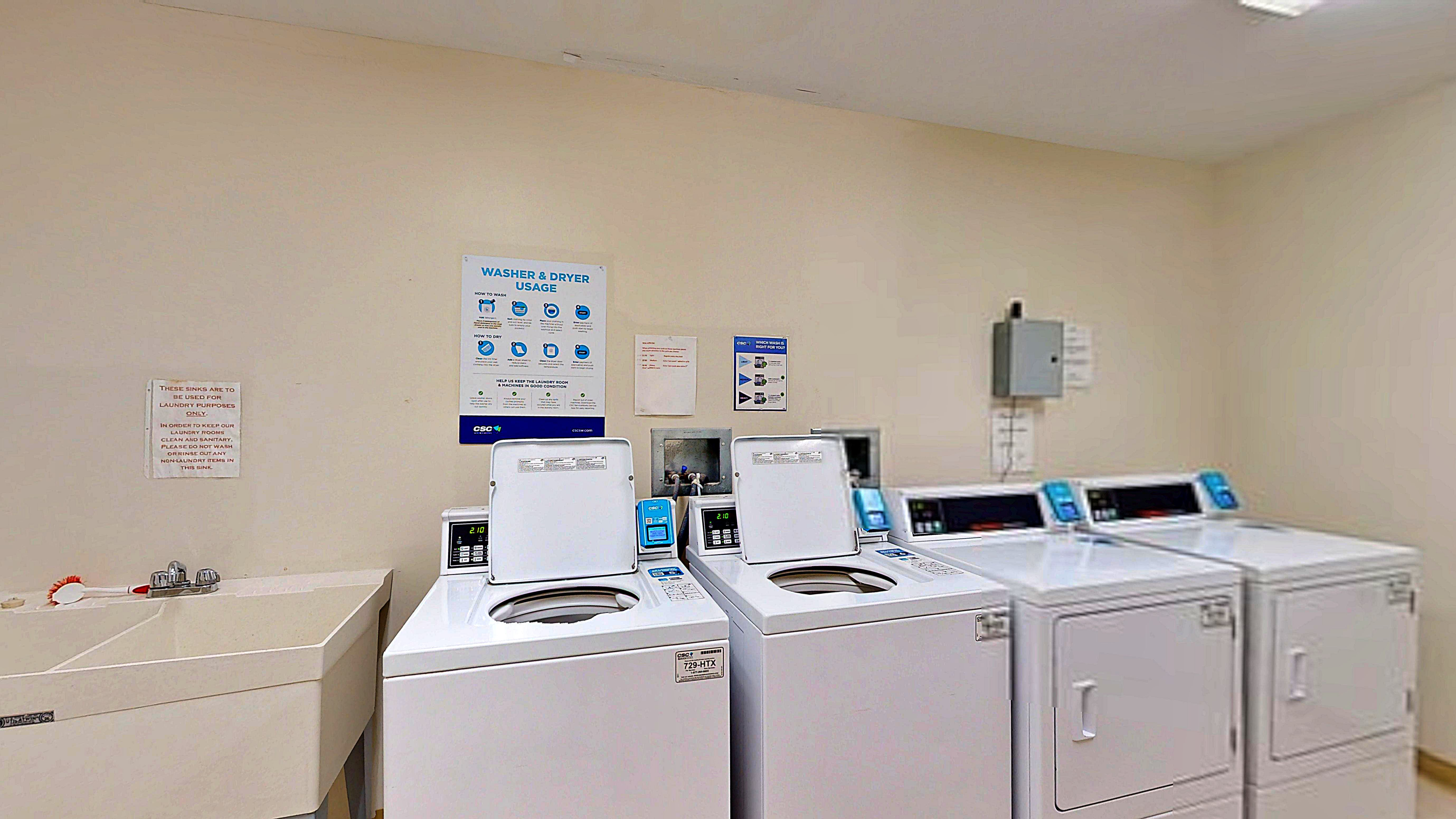 Modern laundry room with state-of-the-art washers and dryers, featuring efficient machines and spacious layout.