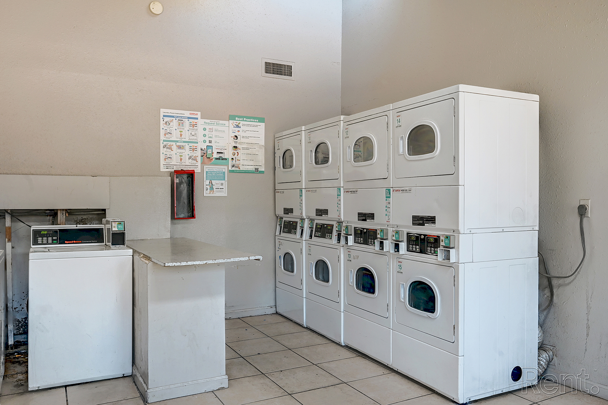 Functional laundry room with modern washing and drying machines in a well-lit space.