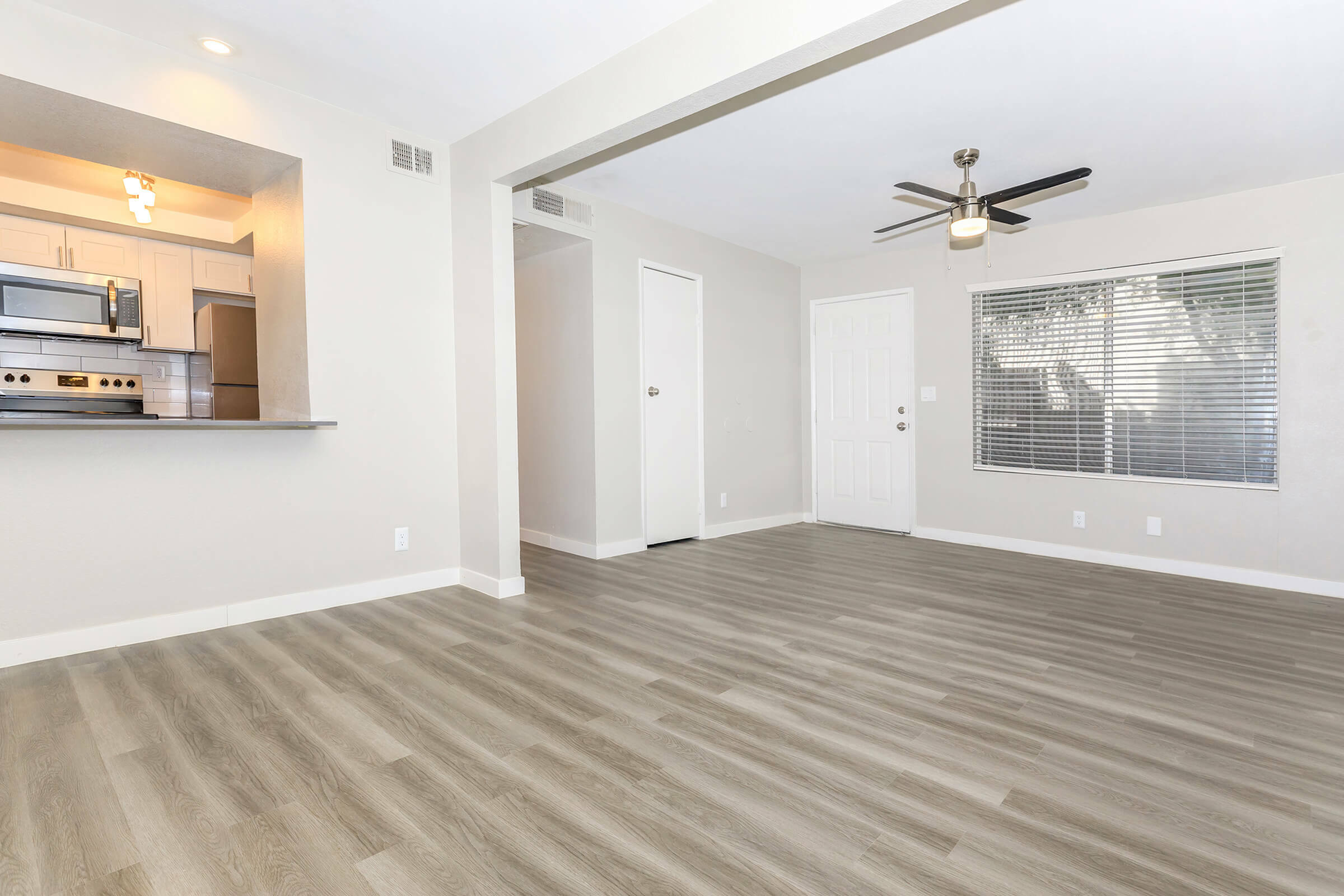 Bright open living area with modern kitchen and hardwood floors.