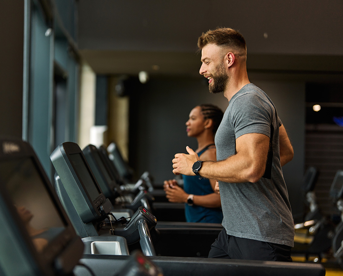 Energetic gym atmosphere with people running on treadmills, capturing the vibrant fitness lifestyle.