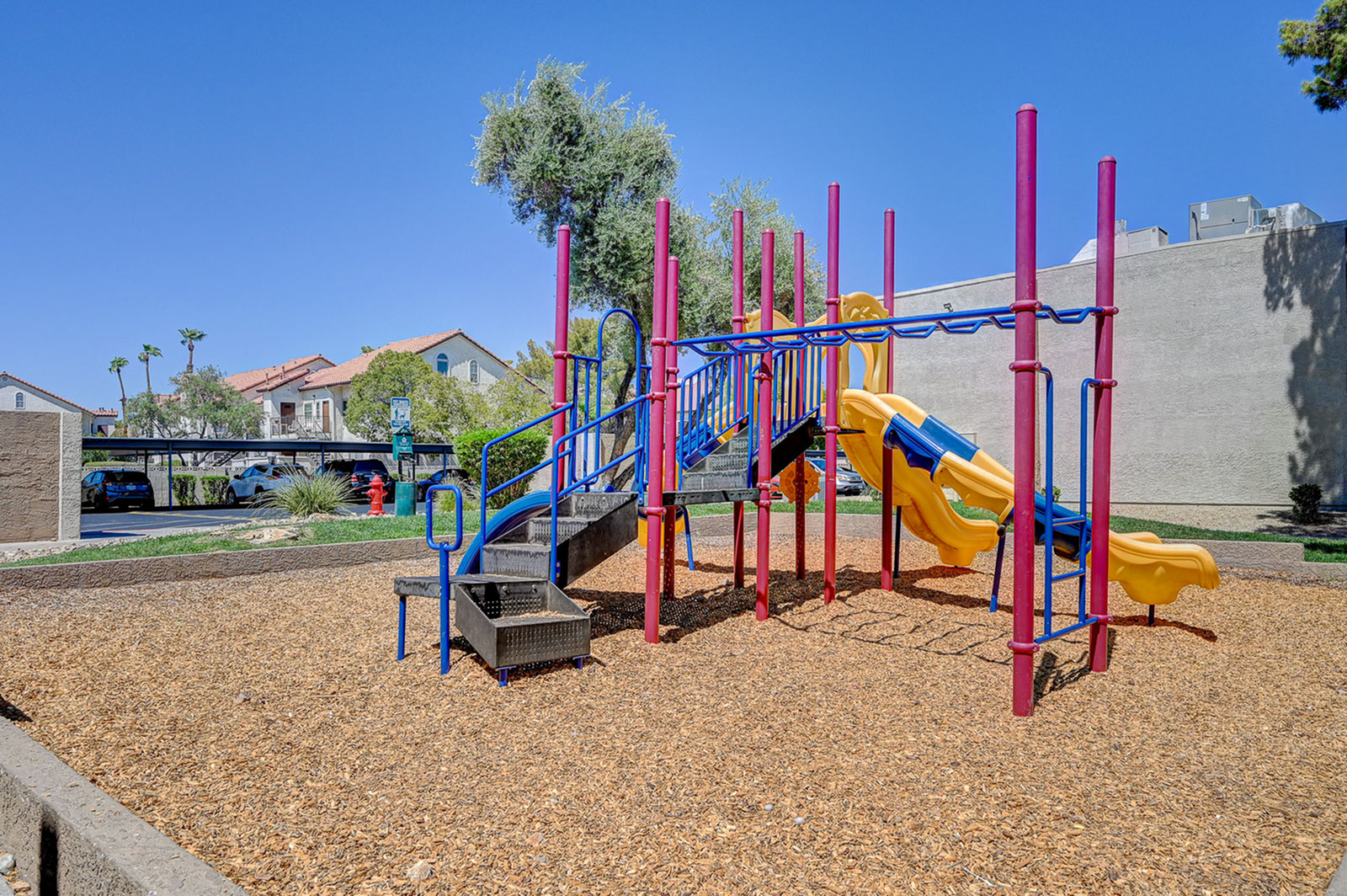 Vibrant community playground featuring a colorful slide and climbing structure, perfect for family fun.