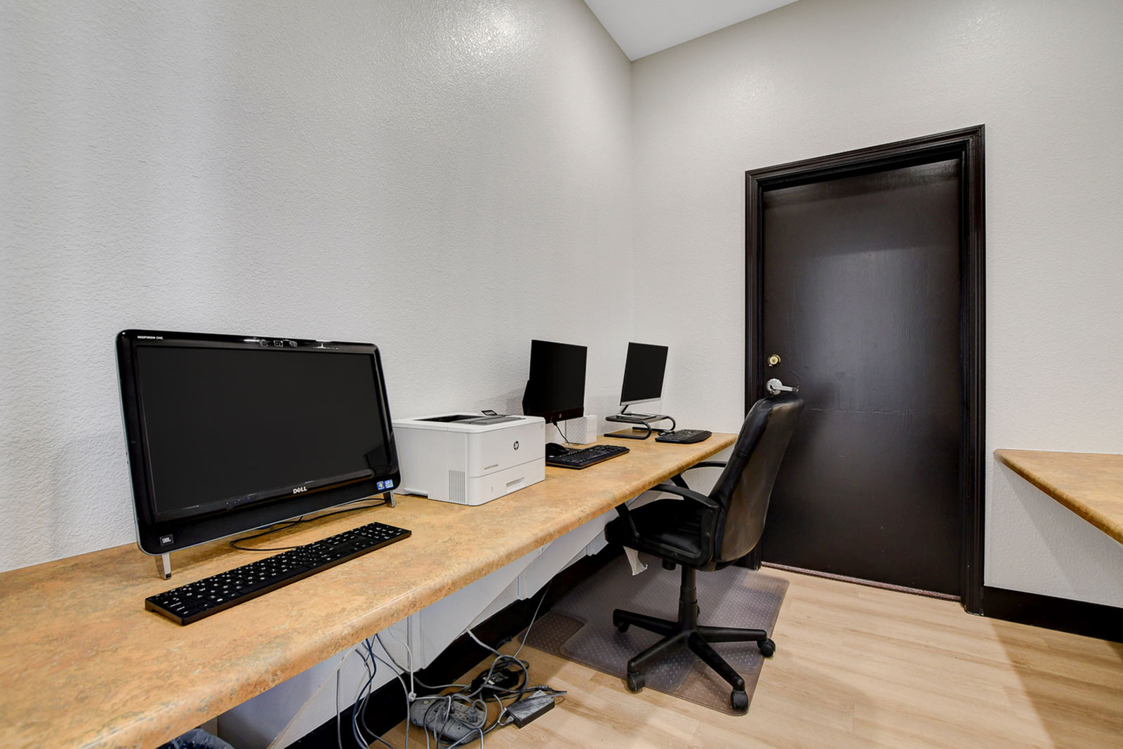 Modern home office setup with sleek workstations, comfortable seating, and a printer for convenience.