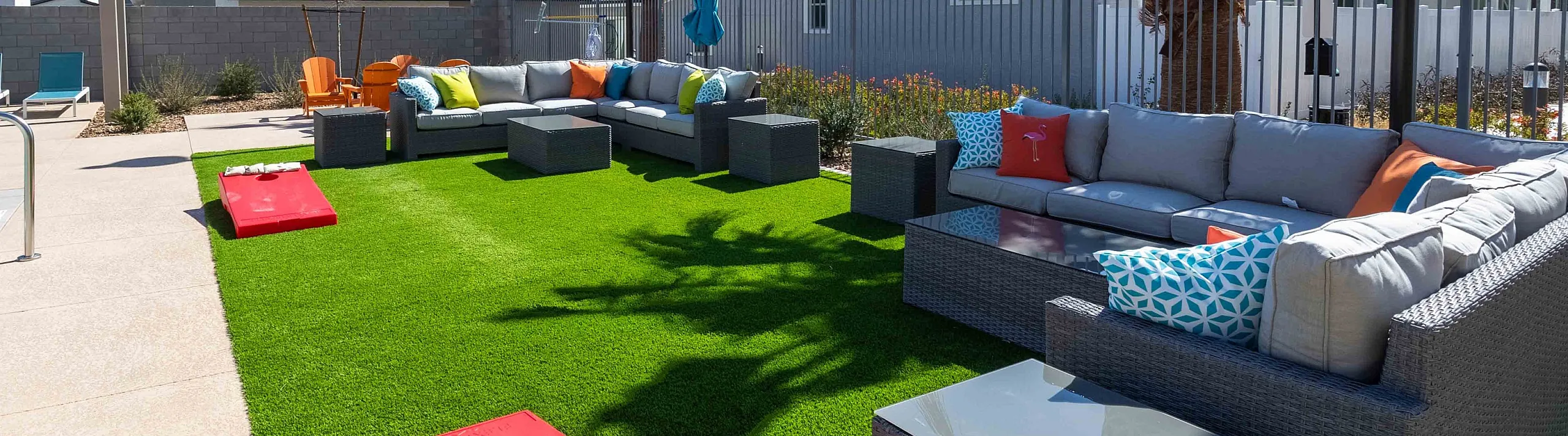 Inviting outdoor lounge area with modern seating, vibrant cushions, and lush greenery.