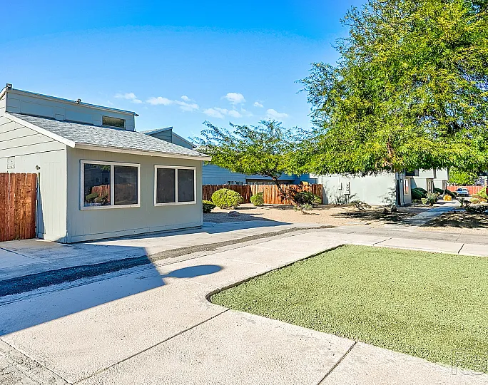 Charming house with a modern facade and large front windows, surrounded by a well-maintained yard.