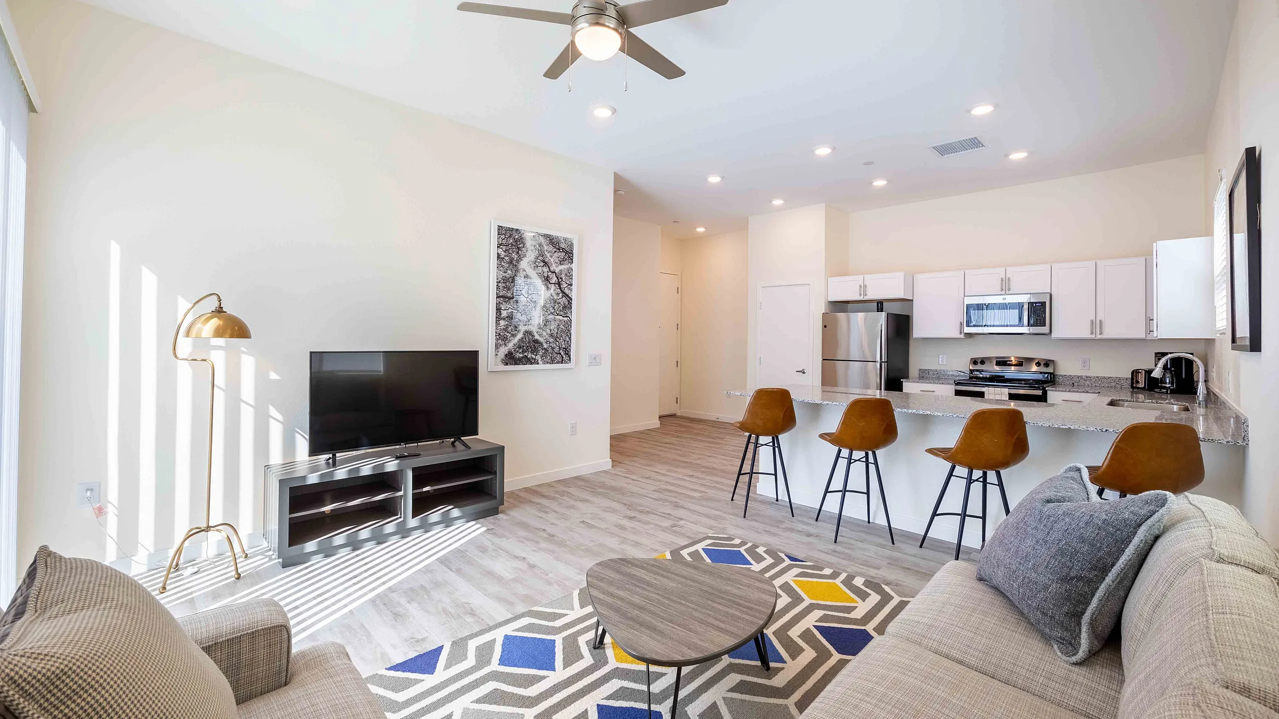 Stylish open-concept living room featuring a modern kitchen, cozy seating, and elegant decor.