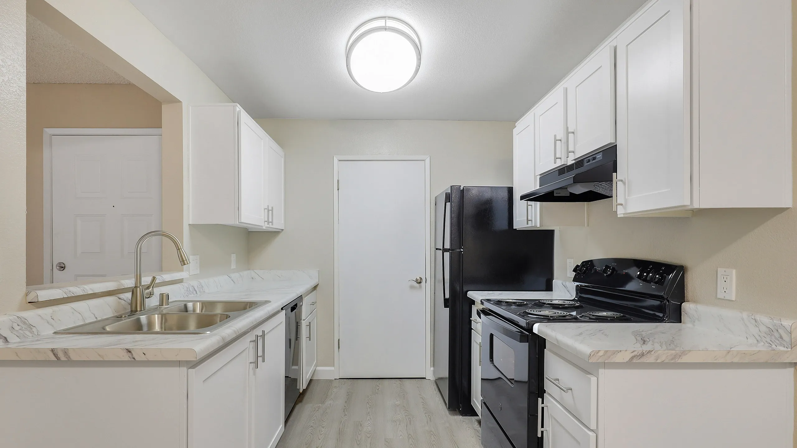 Sleek kitchen with white cabinets, stainless steel sink, and modern appliances.