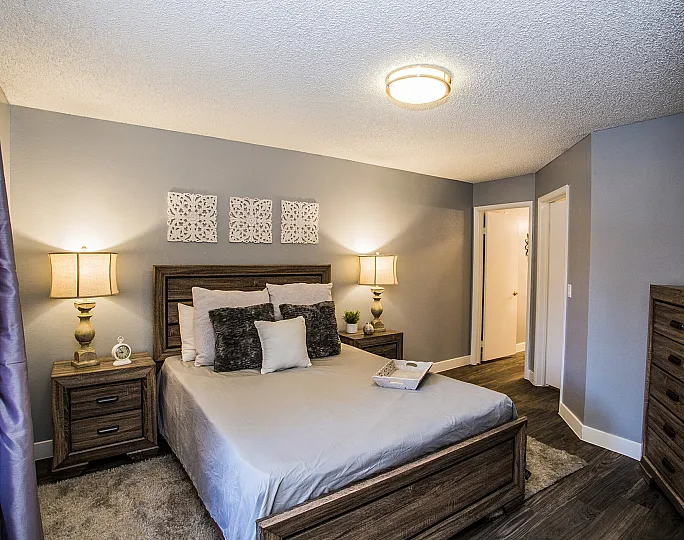 Elegant bedroom with modern furnishings, featuring a cozy bed, warm lighting, and decorative accents.