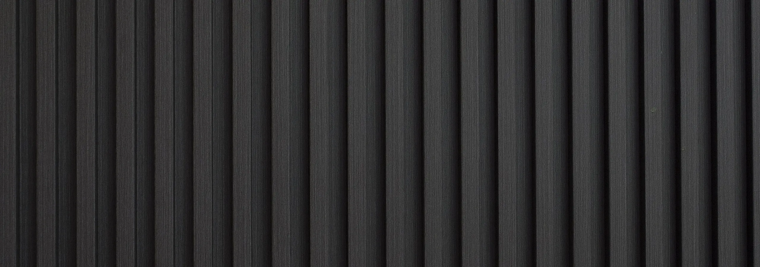 Contemporary, sleek black textured wall with vertical lines, adding a modern touch to interior design.