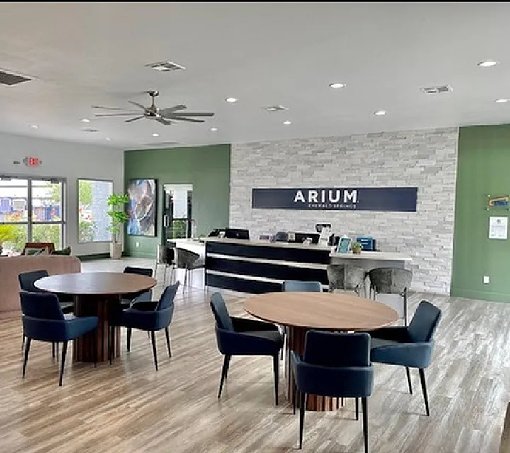 Bright and modern leasing office with stylish furniture, elegant reception desk, and natural light streaming through windows.