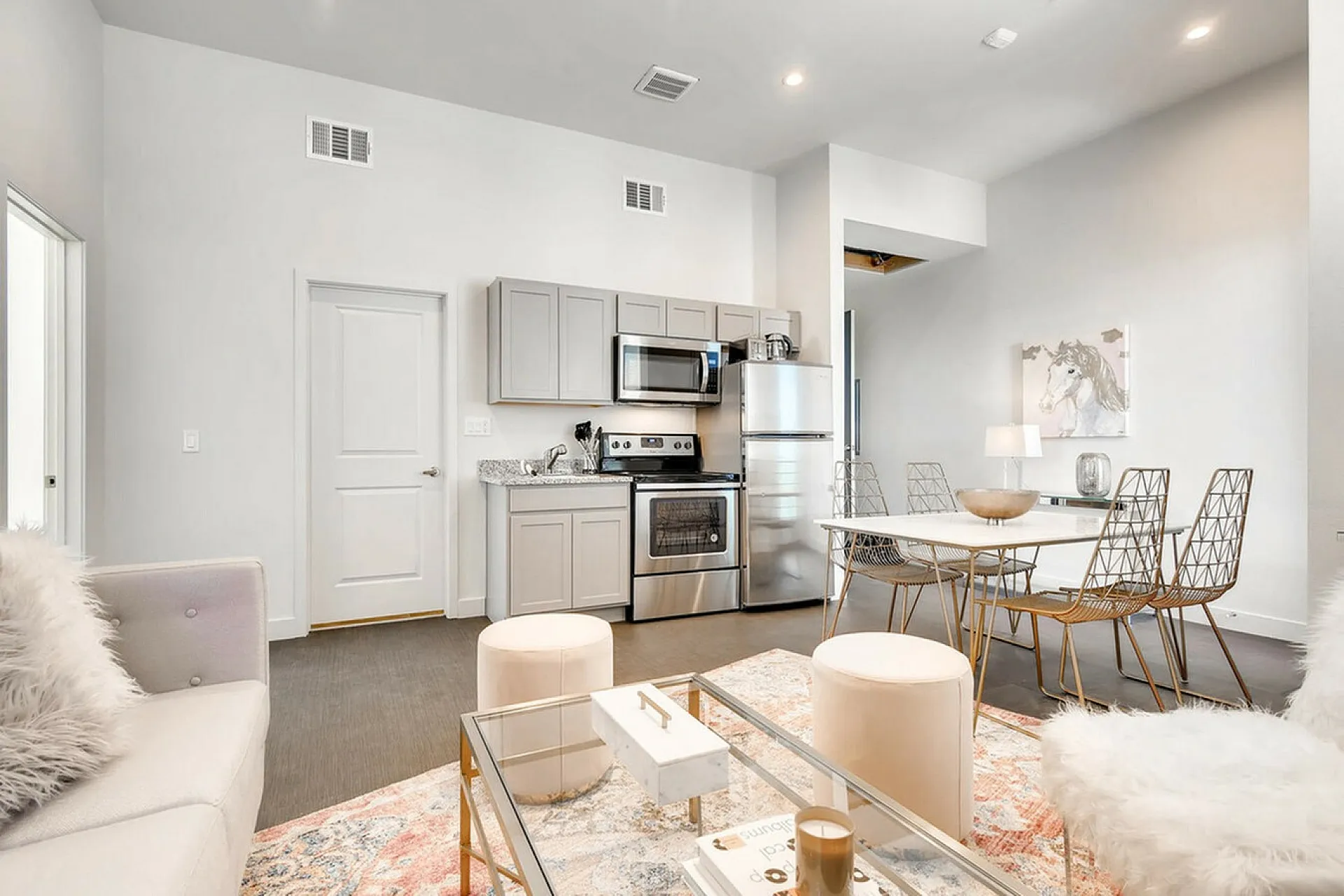 Modern open-concept living and kitchen area with sleek appliances, stylish furnishings, and elegant decor accents.