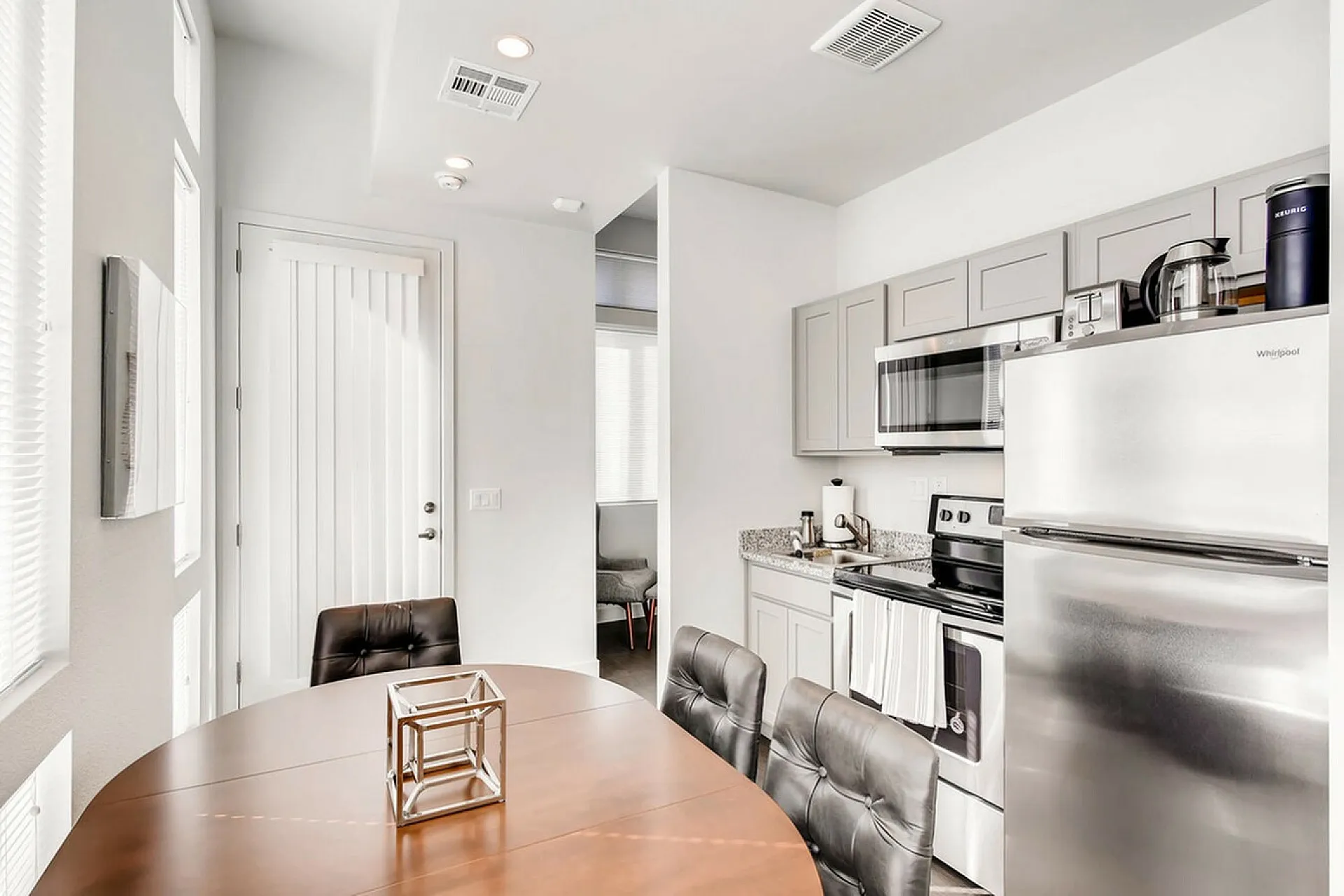 Modern kitchen with sleek stainless steel appliances, elegant cabinetry, and a cozy dining area with abundant natural light.