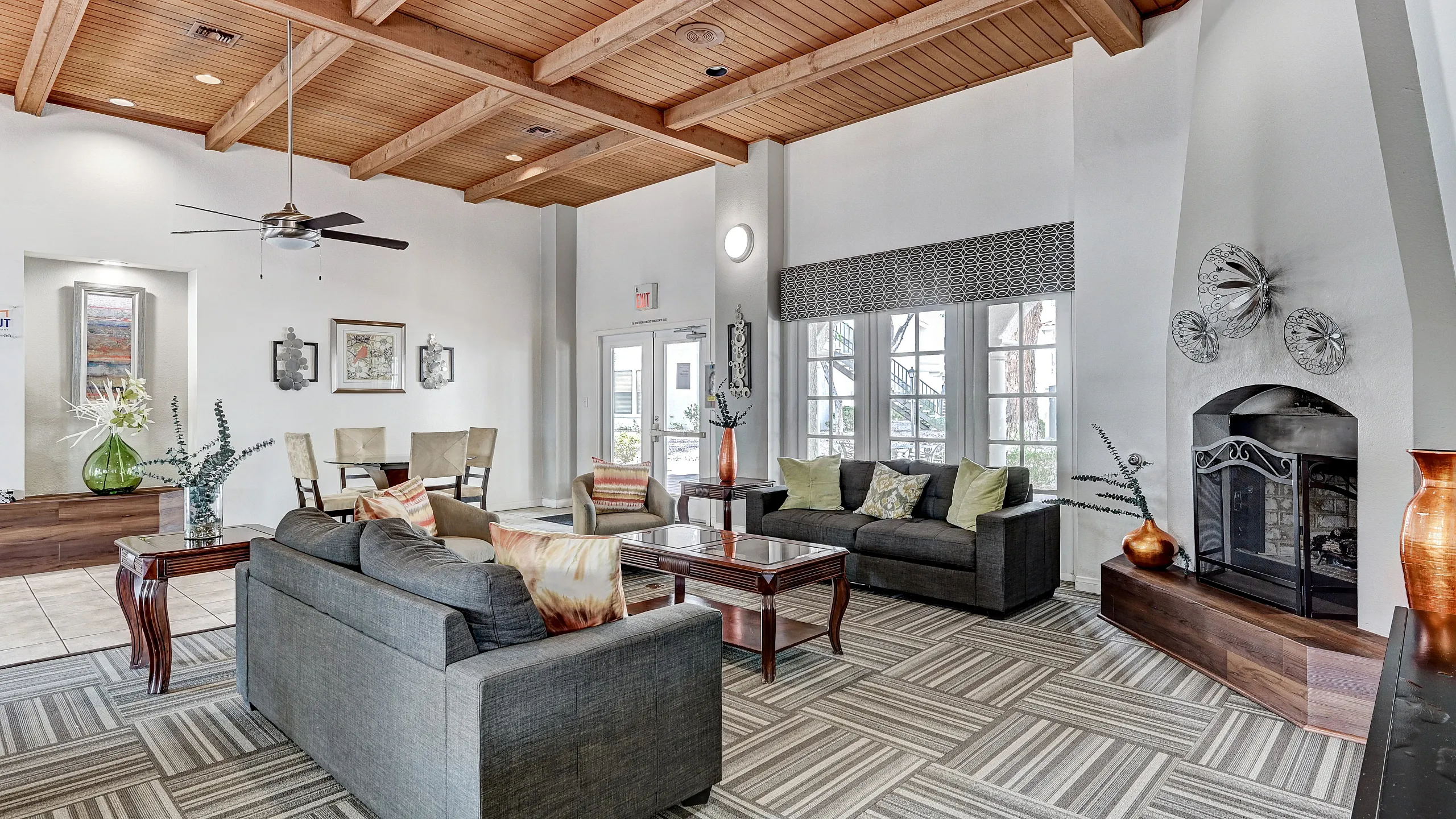 Elegant living space with modern design featuring cozy gray sofas, a striking fireplace, and airy natural light. Perfect for relaxation and social gatherings.