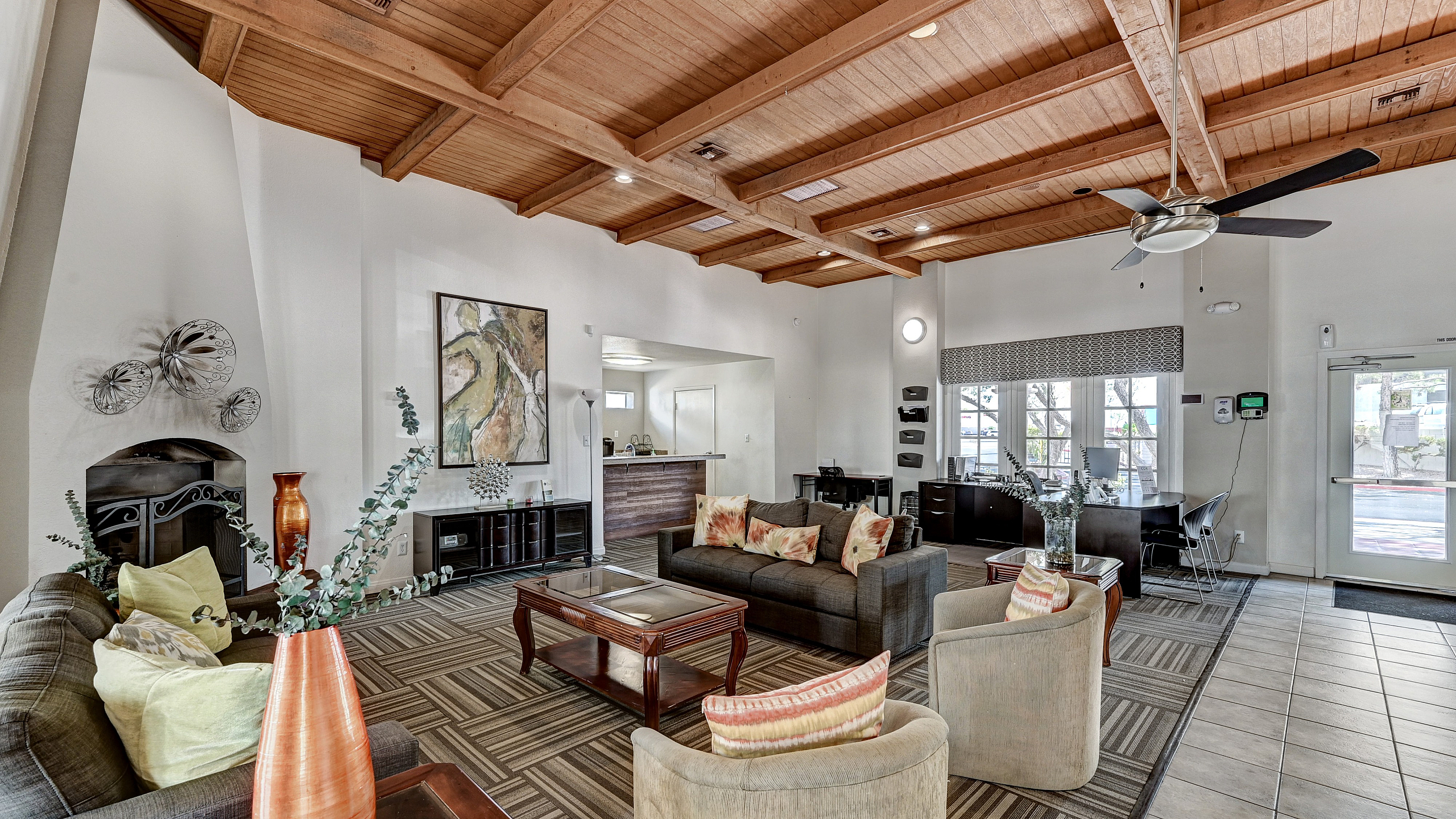 Inviting apartment lobby with elegant wooden ceiling, cozy seating area, and modern decor.