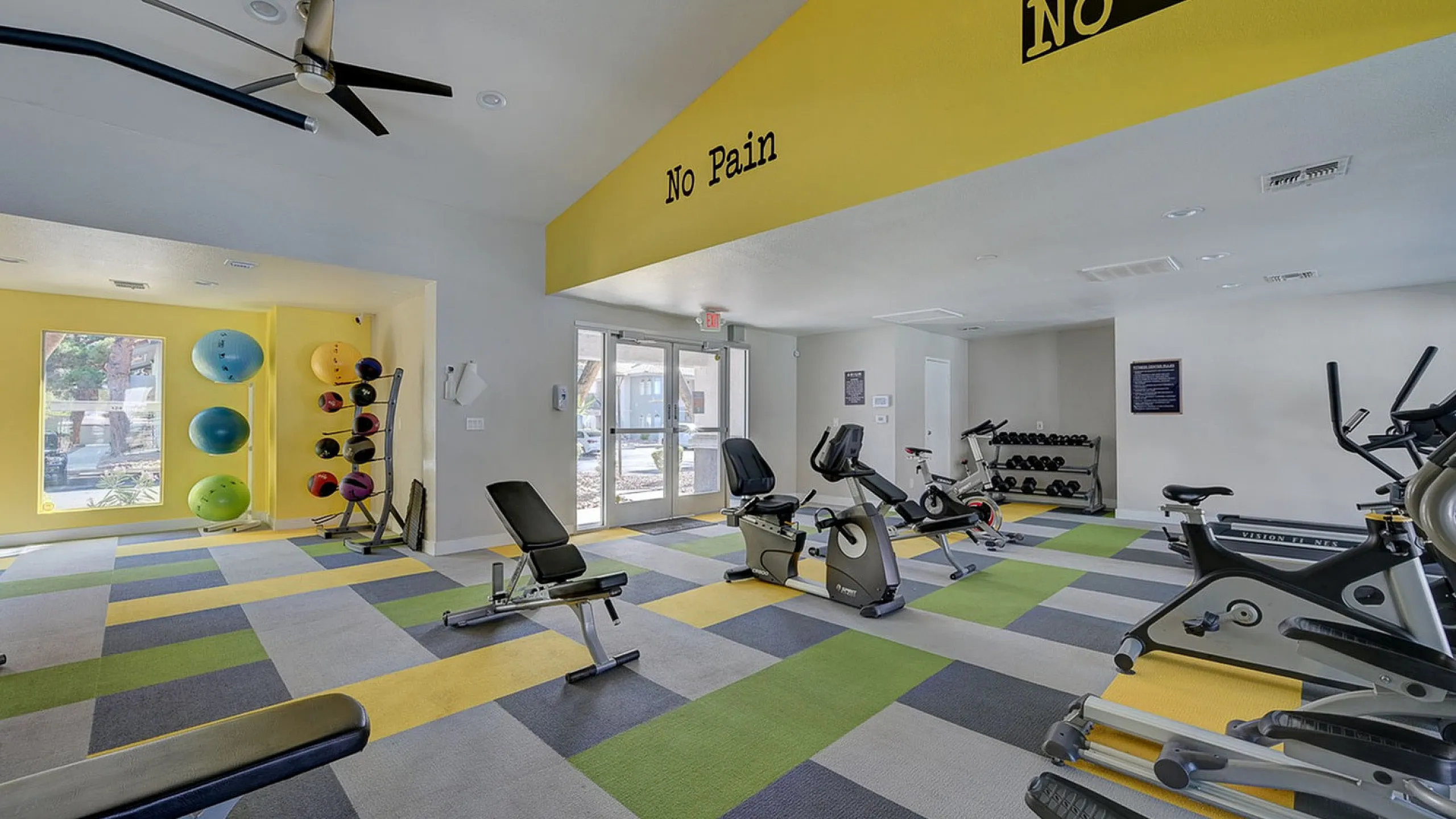 Vibrant fitness center with modern exercise equipment, colorful wall decor, and bright, inviting atmosphere.