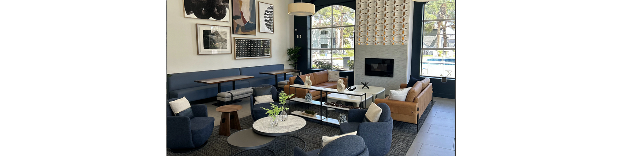 Elegant living room with contemporary design, featuring stylish sofas, modern art, and large windows overlooking a scenic view.