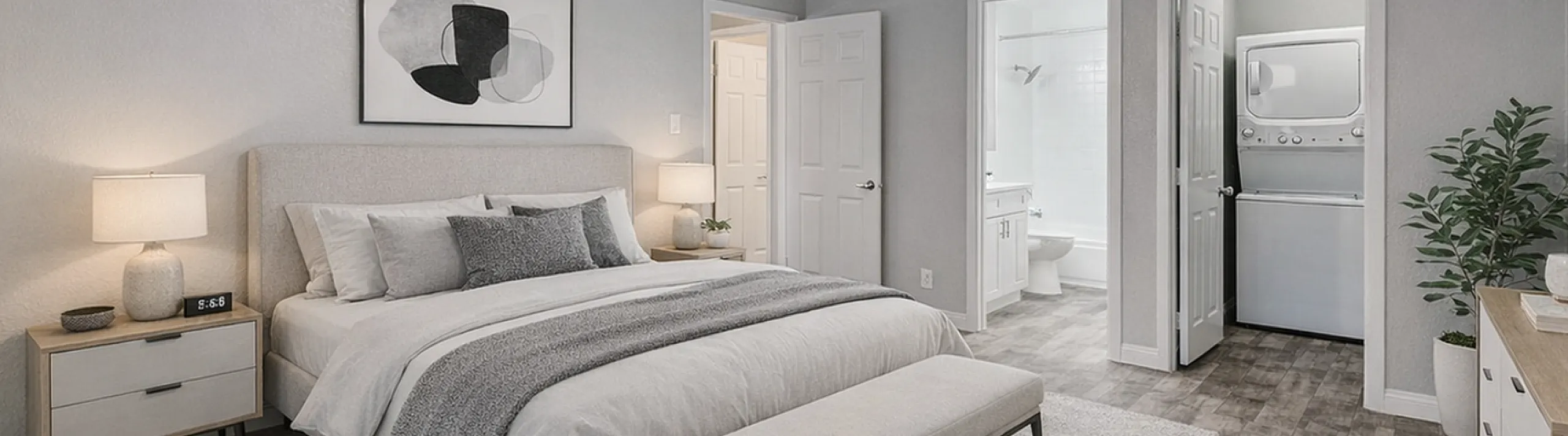 Modern bedroom with elegant decor, featuring a king-sized bed, stylish ceiling fan, and ensuite bathroom. Includes a convenient in-unit laundry area with washer and dryer.