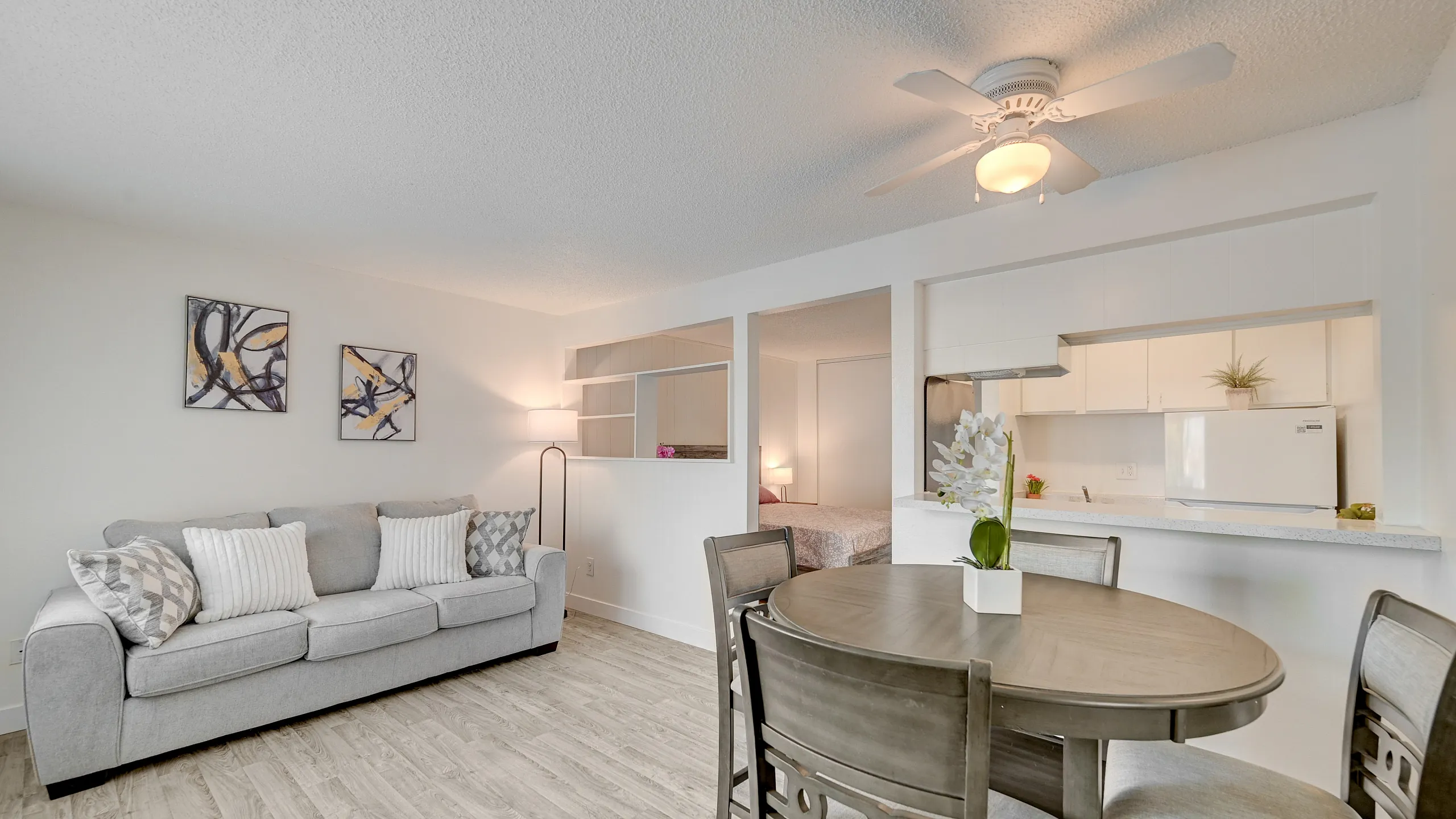 Bright and inviting living space featuring a cozy sofa, elegant dining area, and open kitchen with modern decor.