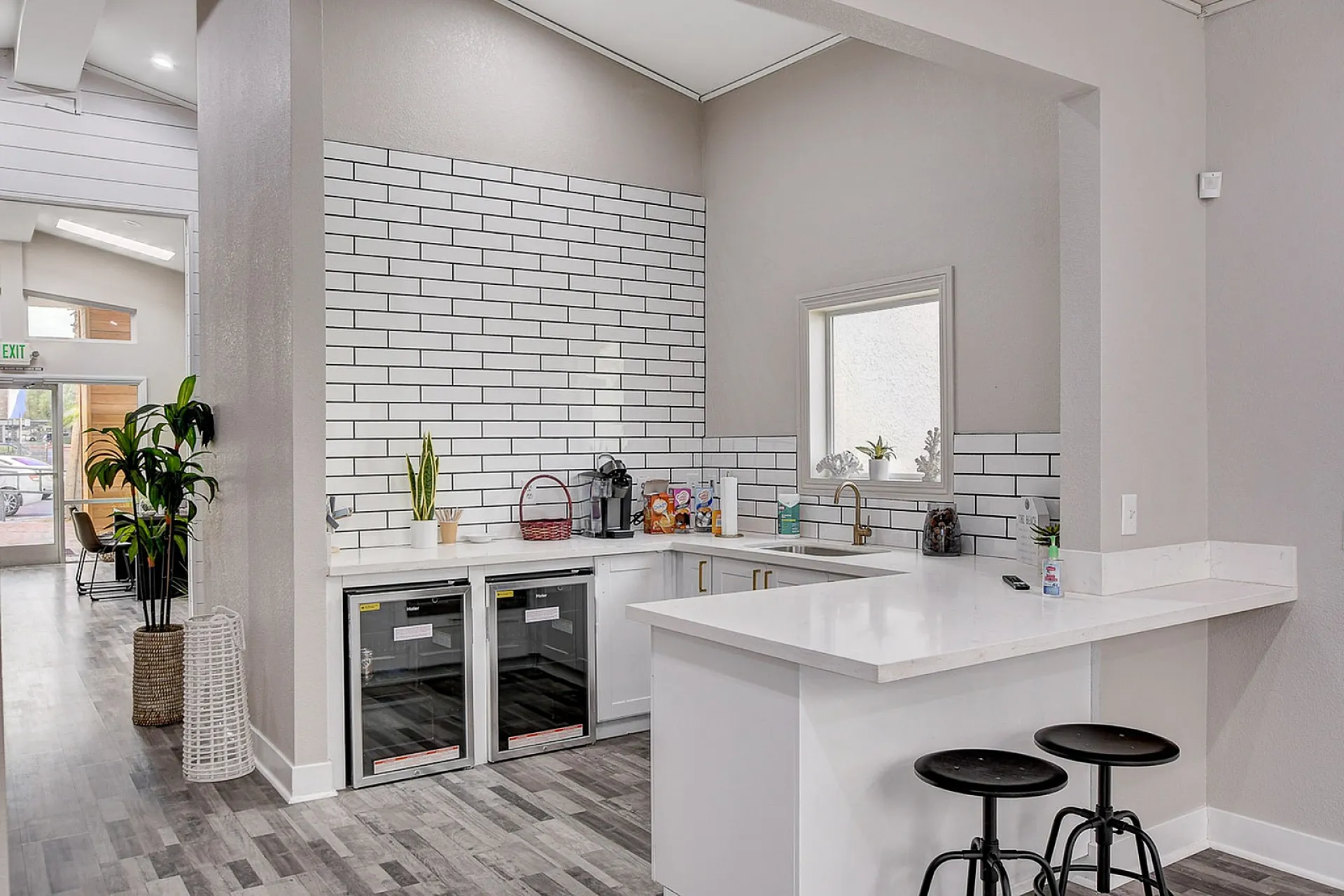 Modern kitchen with sleek white countertops, stylish subway tile backsplash, and contemporary seating, exuding a fresh and inviting ambiance.