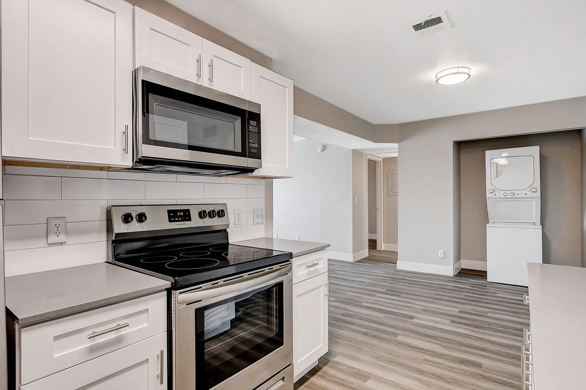 Sleek modern kitchen with stainless steel appliances, elegant cabinetry, and in-unit laundry, offering contemporary living convenience.