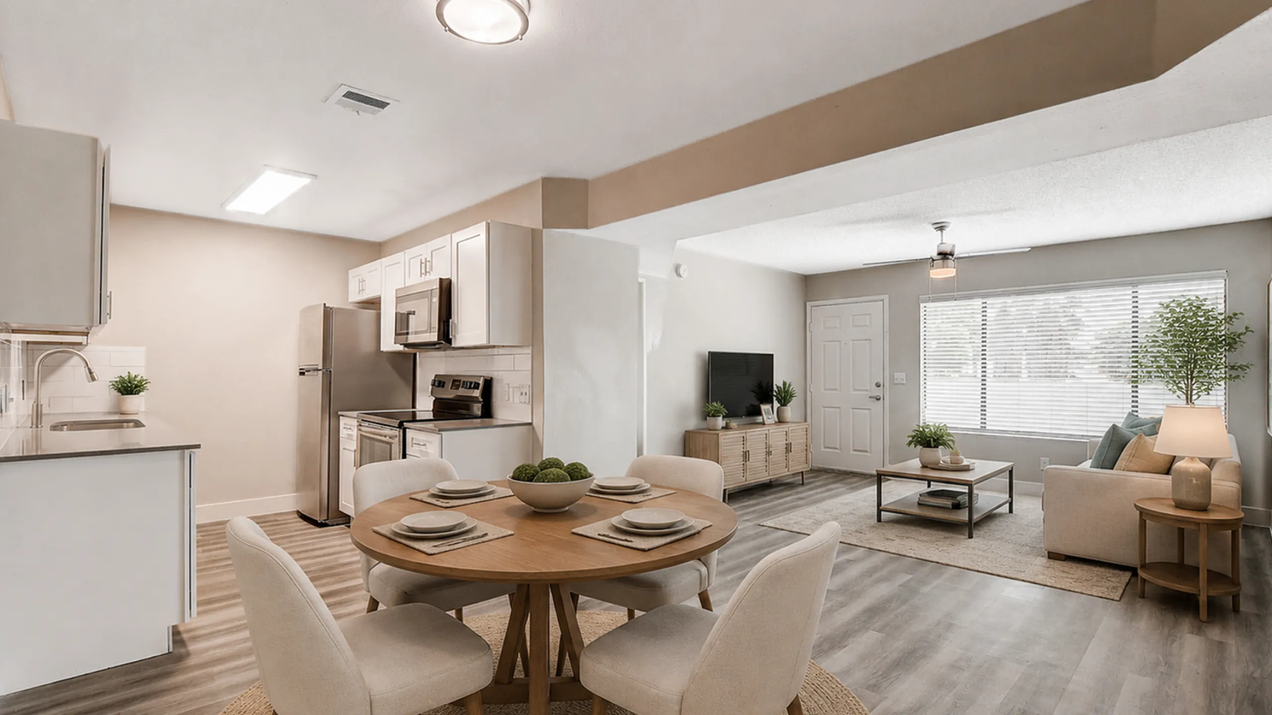 Chic open-concept living space with modern kitchen, dining area, and cozy lounge, featuring elegant decor and abundant natural light.