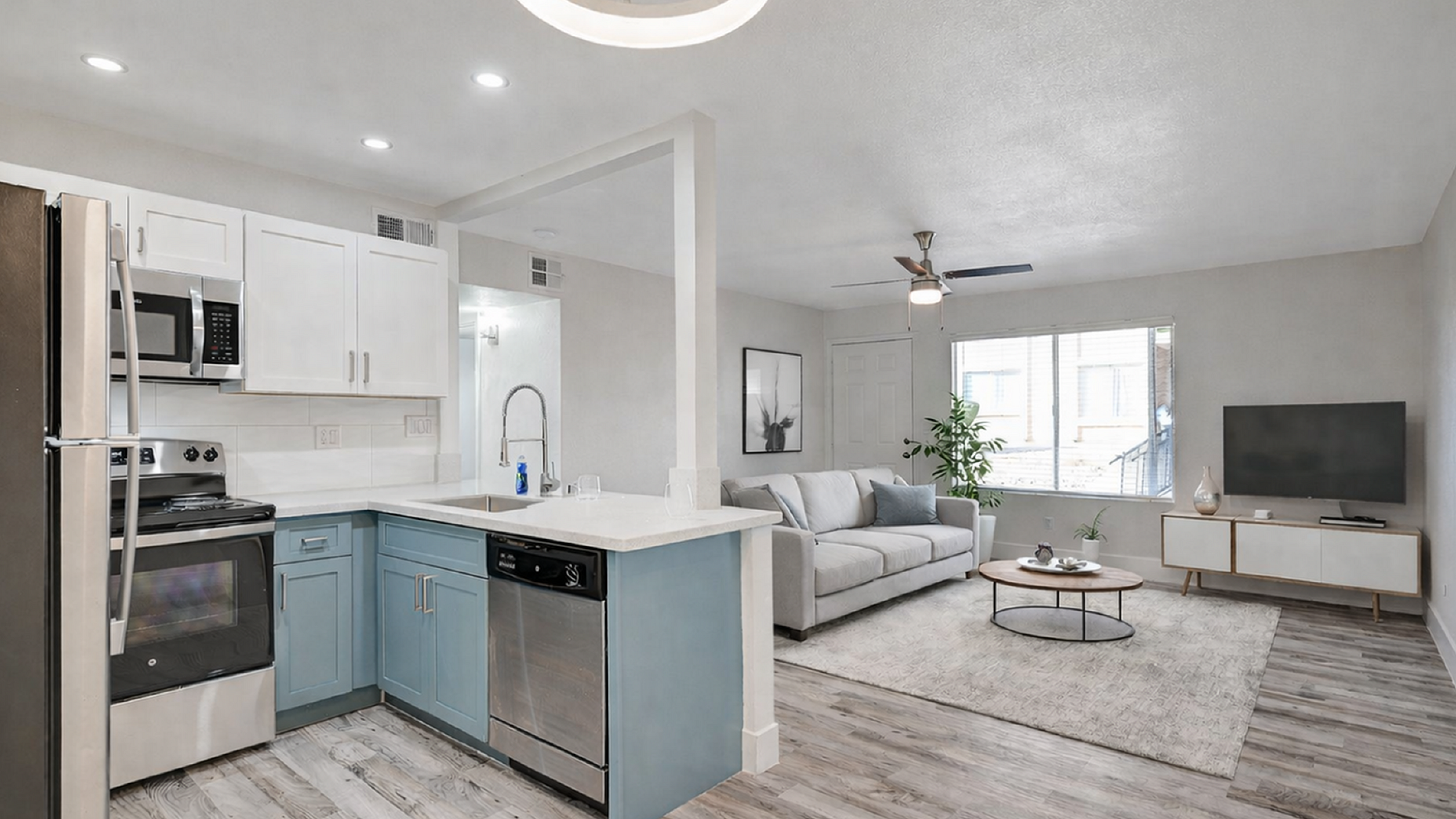 Modern open-plan living space with sleek kitchen, stylish living room, and natural light.