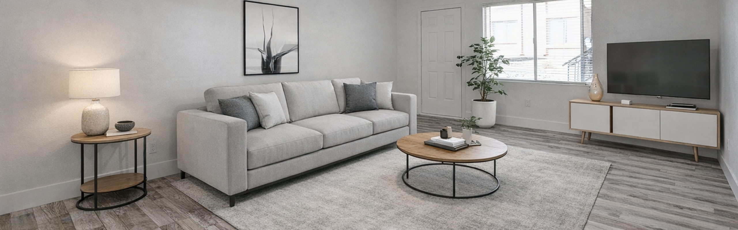 Modern living room with a cozy gray sofa, sleek coffee table, ceiling fan, and elegant decor, featuring large windows for ample natural light.