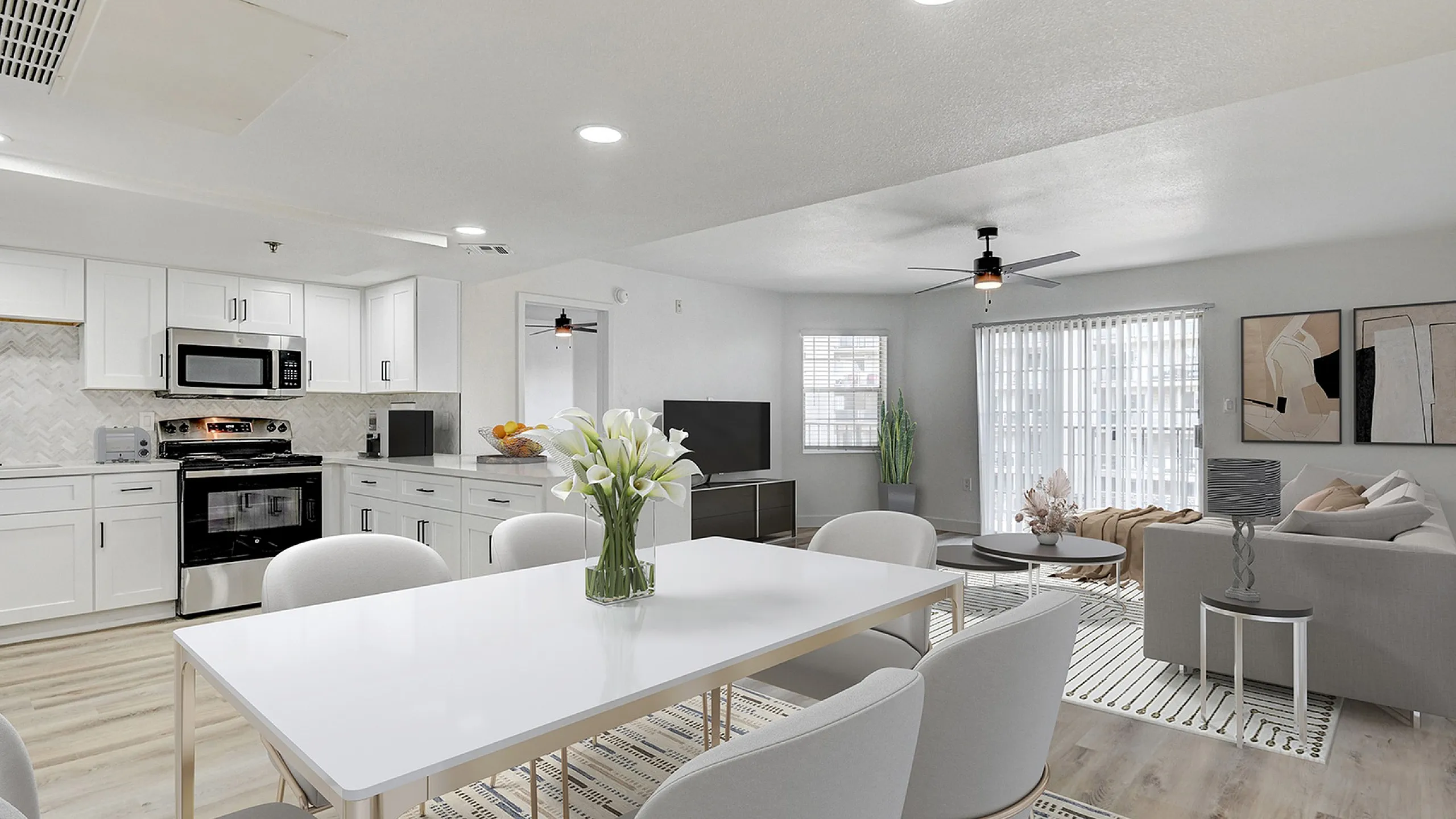 Modern open-concept living and dining area with elegant white kitchen, stylish furnishings, and abundant natural light.