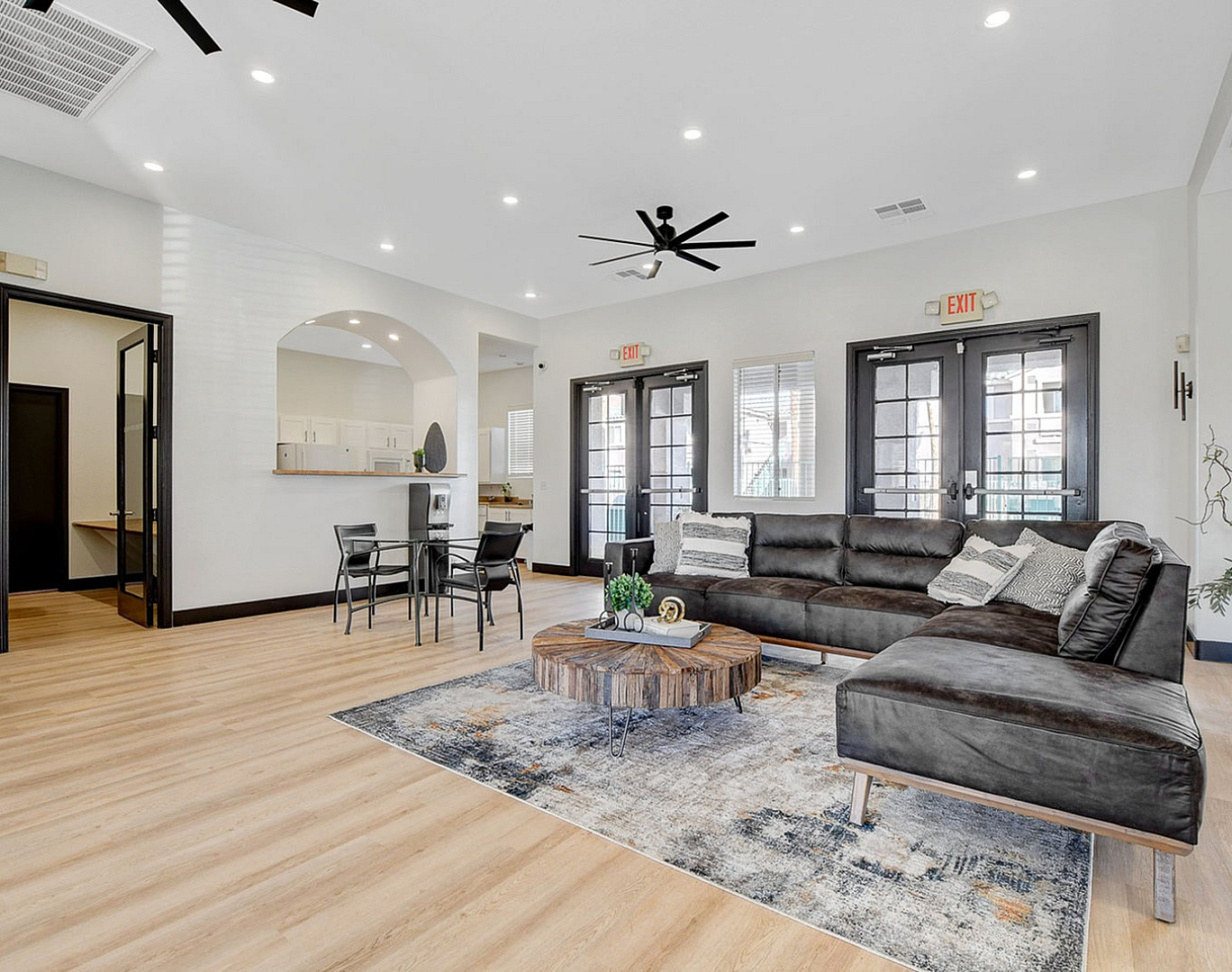 Chic living area featuring a modern sectional sofa, stylish coffee table, and a cozy dining nook in an open-concept layout with abundant natural light.