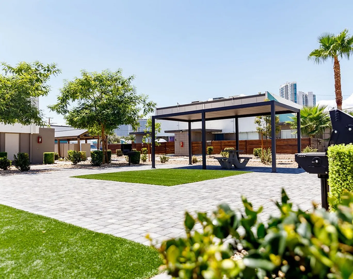 Inviting outdoor space with lush landscaping, a modern pergola, and a barbecue area, perfect for relaxation and gatherings.