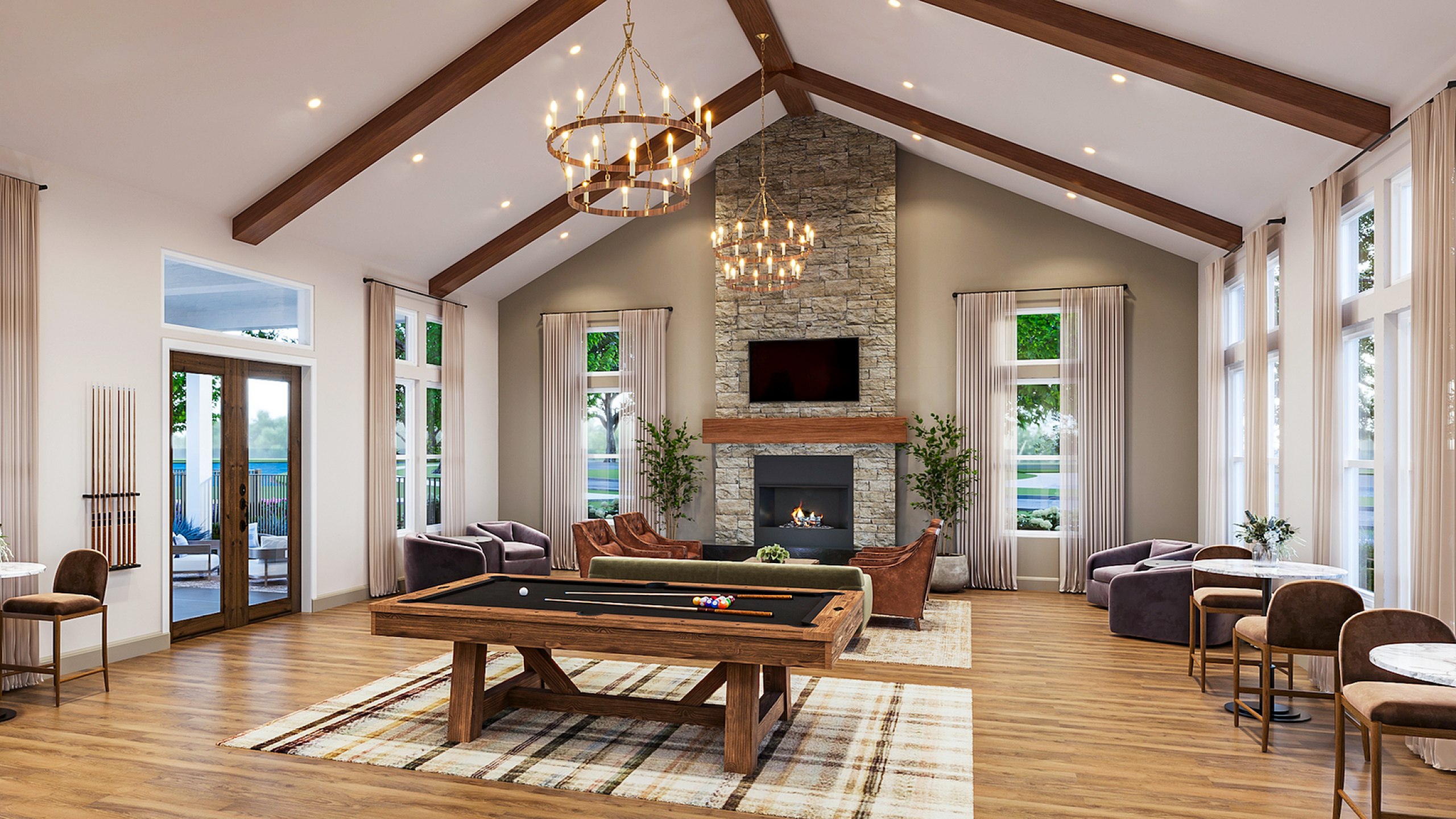 Elegant lounge with vaulted ceilings, modern chandeliers, and a cozy stone fireplace, featuring a stylish billiards table and sophisticated seating arrangement.