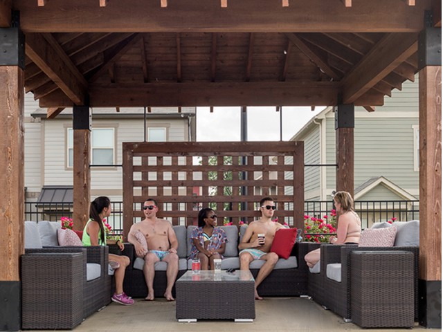 residents utilizing the lounge seating in a poolside cabana