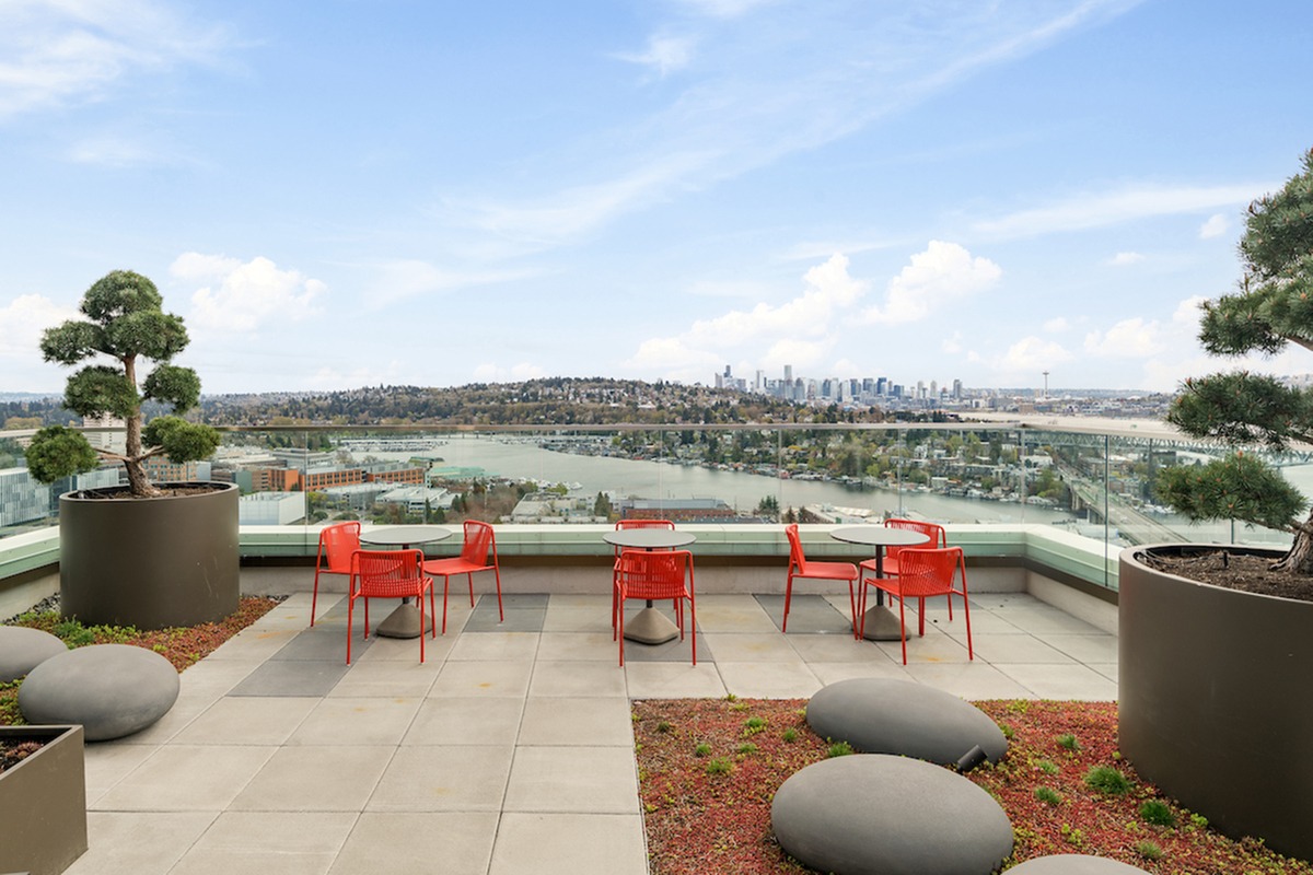Rooftop lounge with tables and chairs looking over the Seattle skyline.